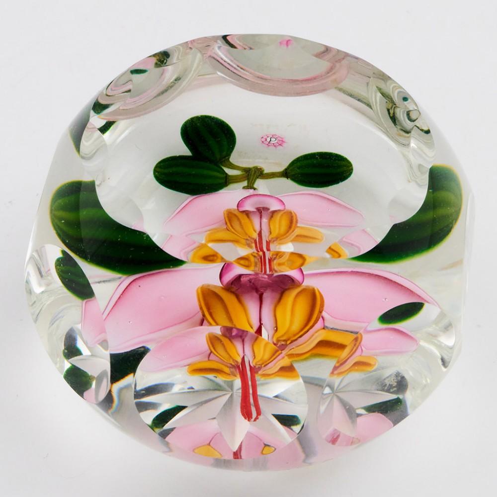 A Perthshire Theobroma Cacao Flower and Pods Paperweight, 1987

Additional information:
Date : 1987
Origin : Scotland
Features : A styalized pink and yellow flower and green pods on a clear ground. One top and eight side facets. 
Marks : A P cane