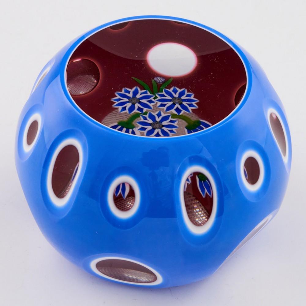 A Perthshire Triple Overlay Paperweight, 1985

Additional information:
Date : 1985
Origin : Scotland
Features : Five blue petaled flowers with white edges forming a bouquet within a triple overlay of blue over white over pink.
Marks : Signed P cane