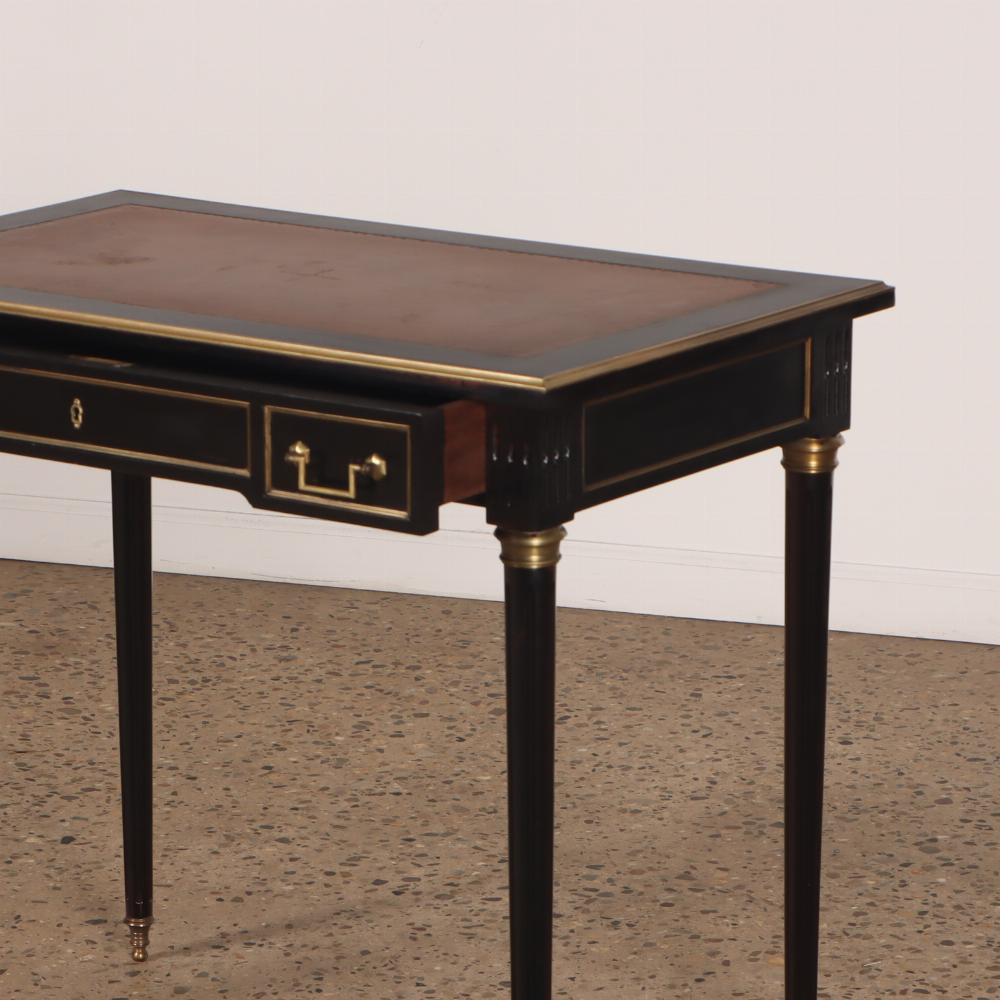 Piccolo scrittoio francese in mogano ebanizzato con piano in pelle in stile Luigi XVI, C.C. Il grembiule è rifinito con modanature in bronzo e presenta un unico cassetto sostenuto da sottili gambe tornite. Si tratta di una dimensione molto difficile