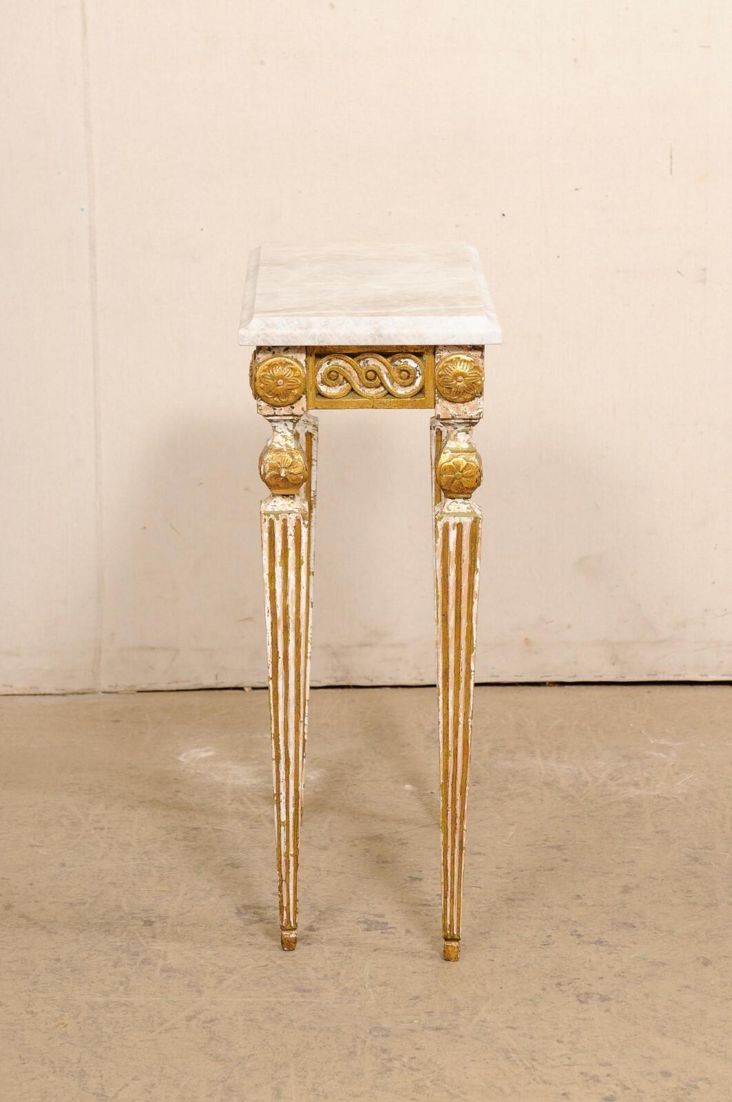 An Italian small-sized carved and gilt wood table with stone top from the early to mid 20th century. This antique table from Italy has been fitted with a new quartzite 
