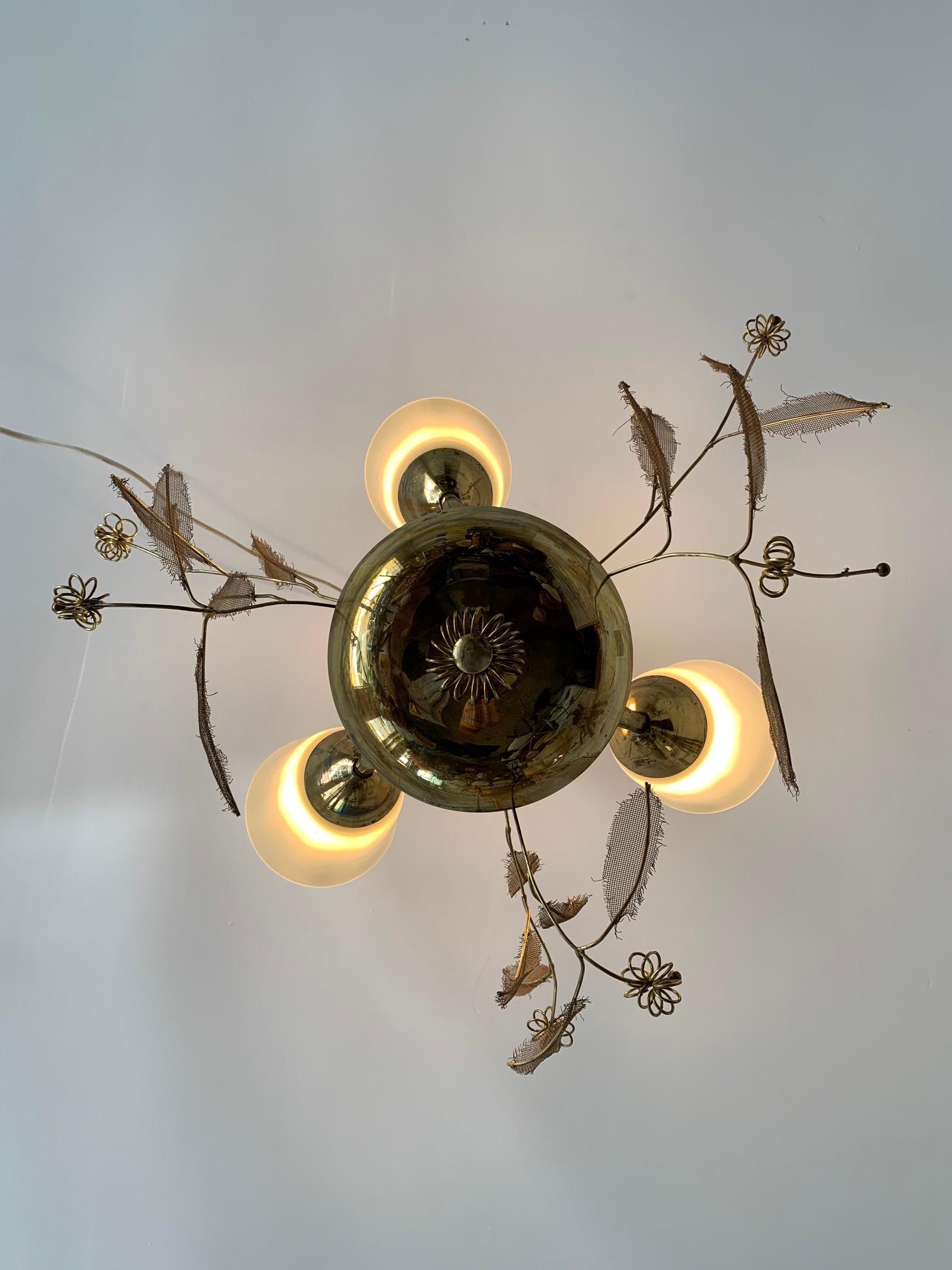 A petite Paavo Tynell chandelier with glass shades and brass and leaf forms.
