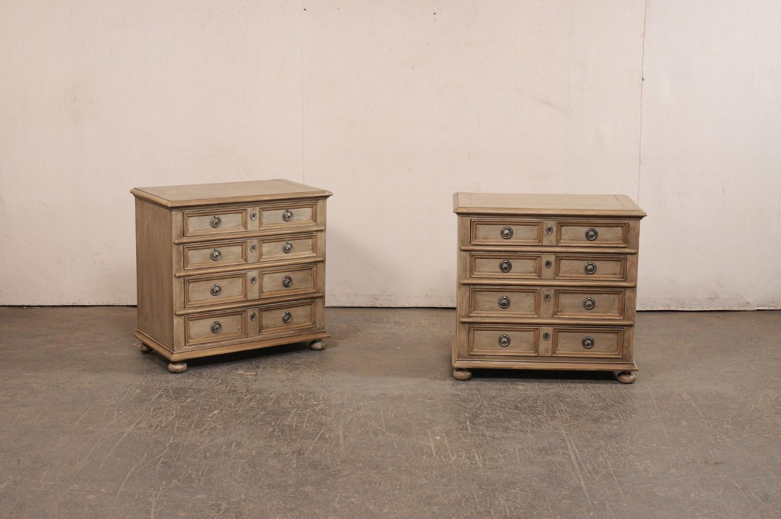 An English pair of petite, painted-wood, four-drawer chests from the mid 20th century. These vintage chests from England each have rectangular-shaped tops with rounded front corners, atop the case which houses four graduated drawers, and are raised