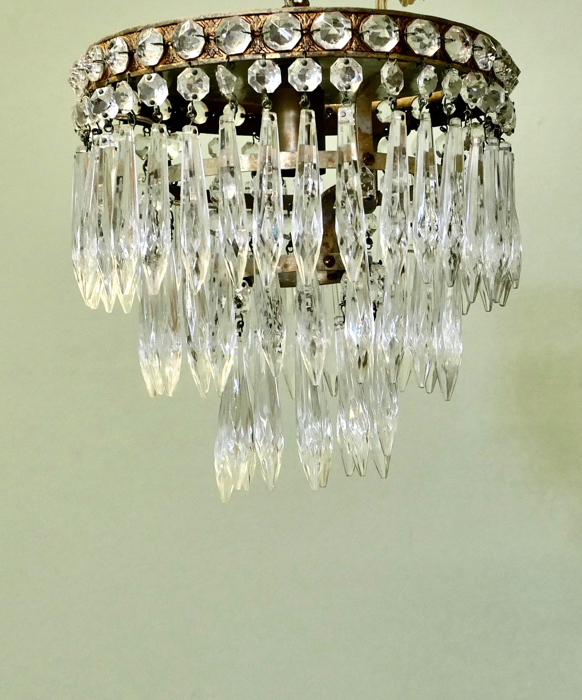 Un lustre à pendentif en forme de petite cascade

Il s'agit d'un magnifique lustre à pendentifs en cascade, ce luminaire délicat comporte trois niveaux de pendentifs en cristal facetté.
Le luminaire est un modèle classique Art Deco des années 1920.