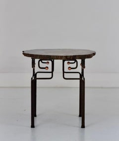 Ein Akzenttisch aus versteinertem Holz auf Eisen- und Kupfersockel