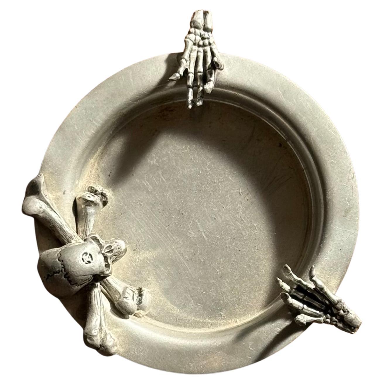 A pewter ashtray ft. skeleton skull and crossbones by Alchemy, 20th century