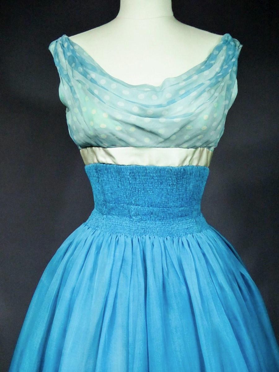 Circa 1958

France

Sumptuous cocktail or ball gown with Princess line by Pierre Balmain Haute Couture numbered 83214. Sleeveless dress with a cowl neckline draped with polka-dot muslin and a sheath bodice with elastic garters! High waist effect