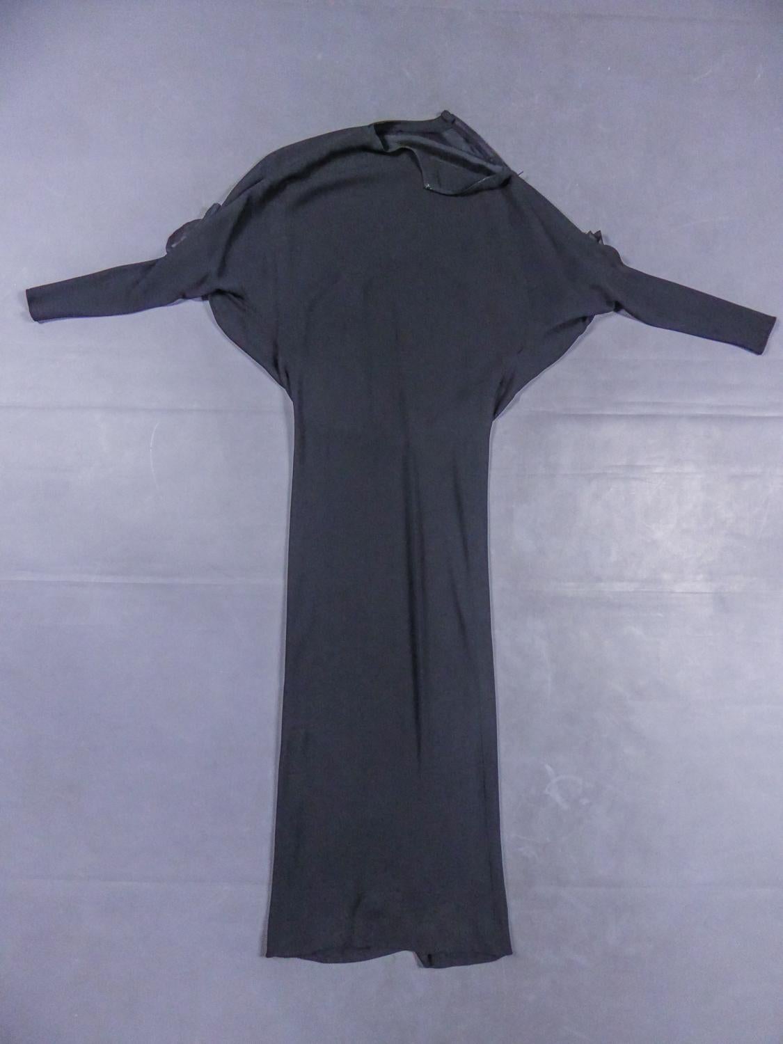 Circa 1976/1978

France

Beautiful evening dress Pierre Cardin Haute Couture in black silk jersey dating from the late 1970s. Crew neck dress in stretchy black silk jersey, with long bat sleeves decorated with two flowers with black silk petals and