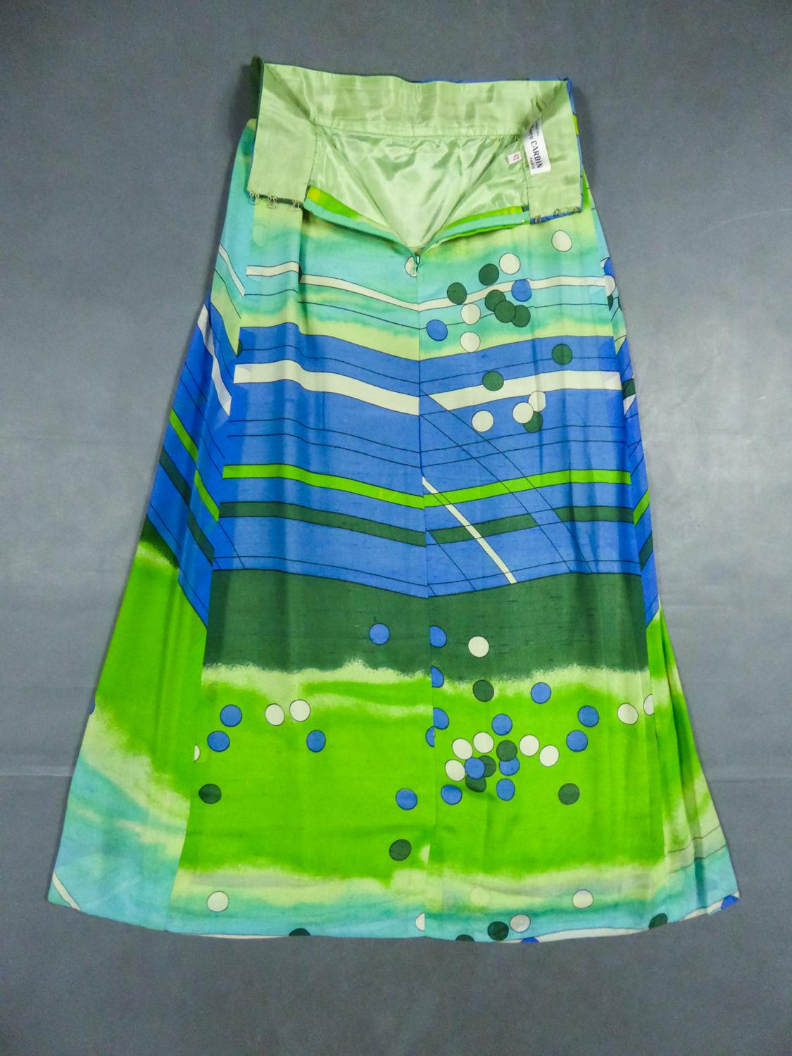 Circa 1975/1980
France

Long skirt by Pierre Cardin Paris Circa 1980. Silk crepe printed in tones of green and blue colors with patterns of geometric lines and circles of Modernist taste. Large waist belt and large box pleats at the front giving the