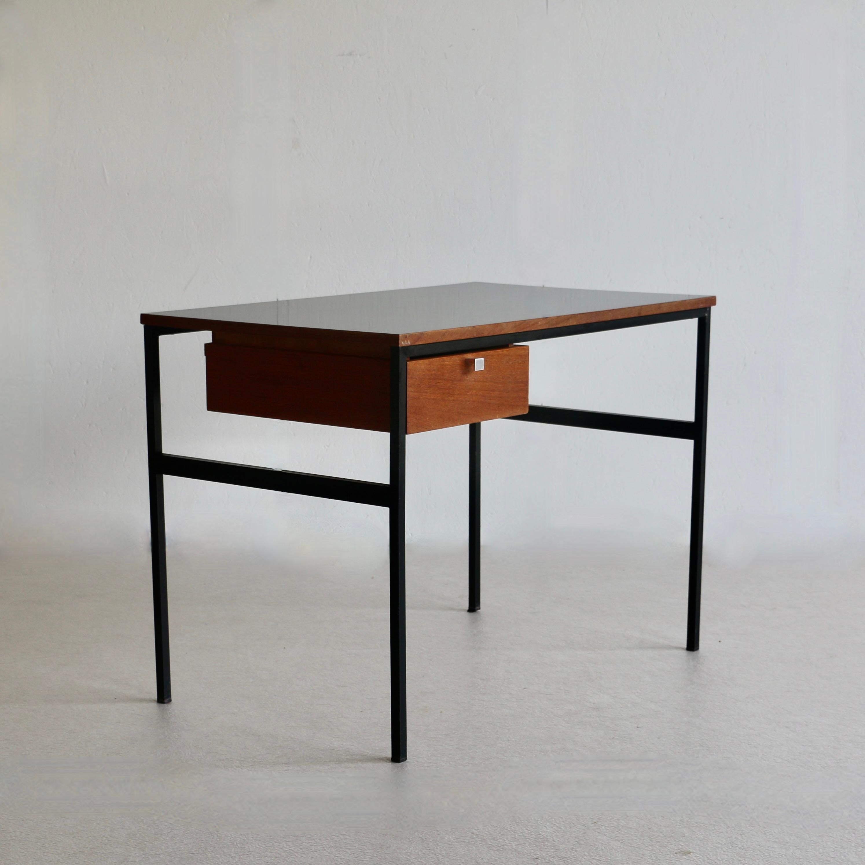 A Pierre Paulin (1922-2009) model CM 217 desk with square tubular legs in black lacquered metal on which rests a plywood top covered with black laminate, suspended pedestal opening with a teak drawer France Edition Thonet 1962.