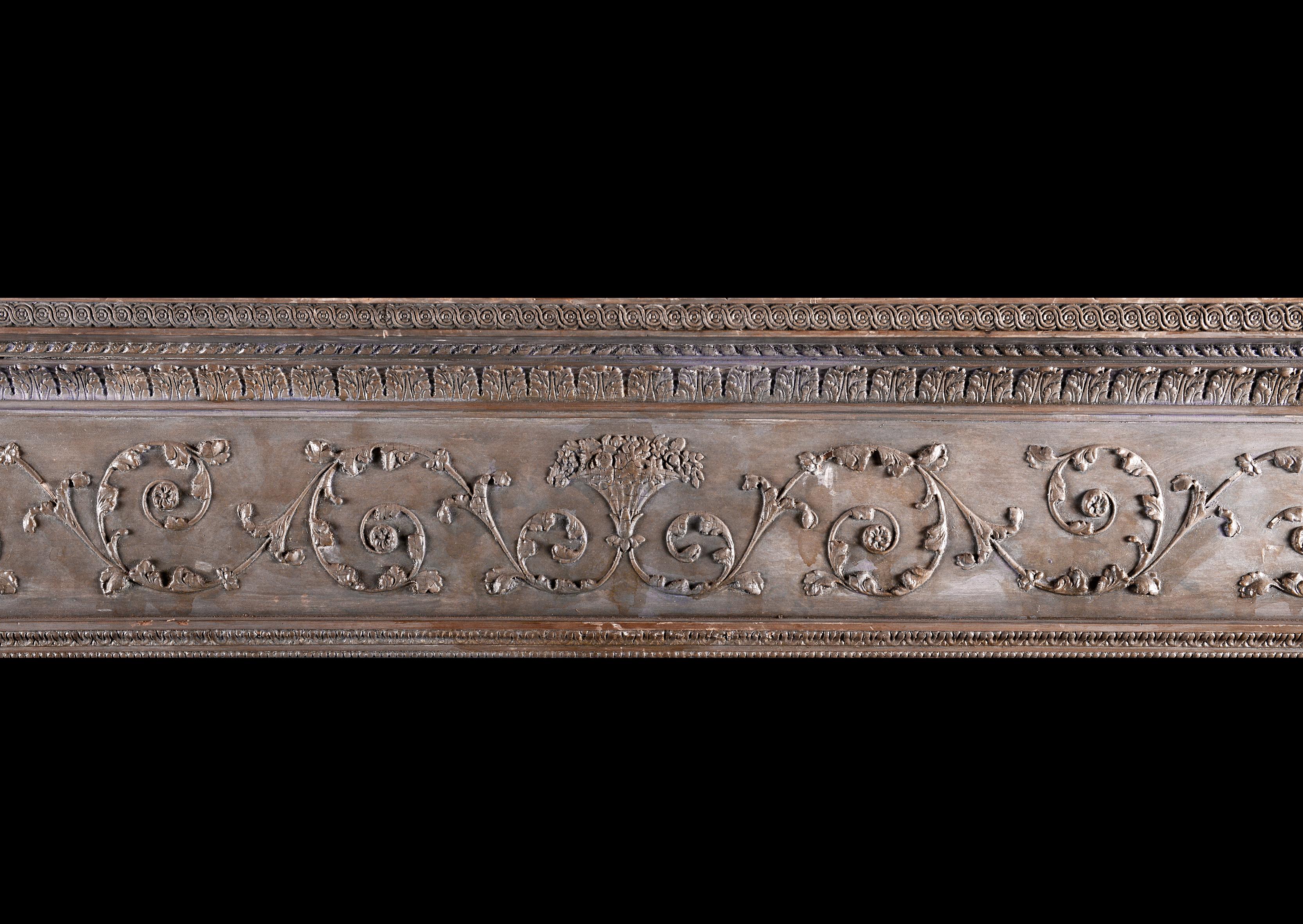 A pine and gesso antique fireplace in the Georgian manner. The jambs with beading, bellflowers and cascading foliage, surmounted by stiff acanthus leaves and classical figures to end blockings. The frieze with scrollwork throughout with floral