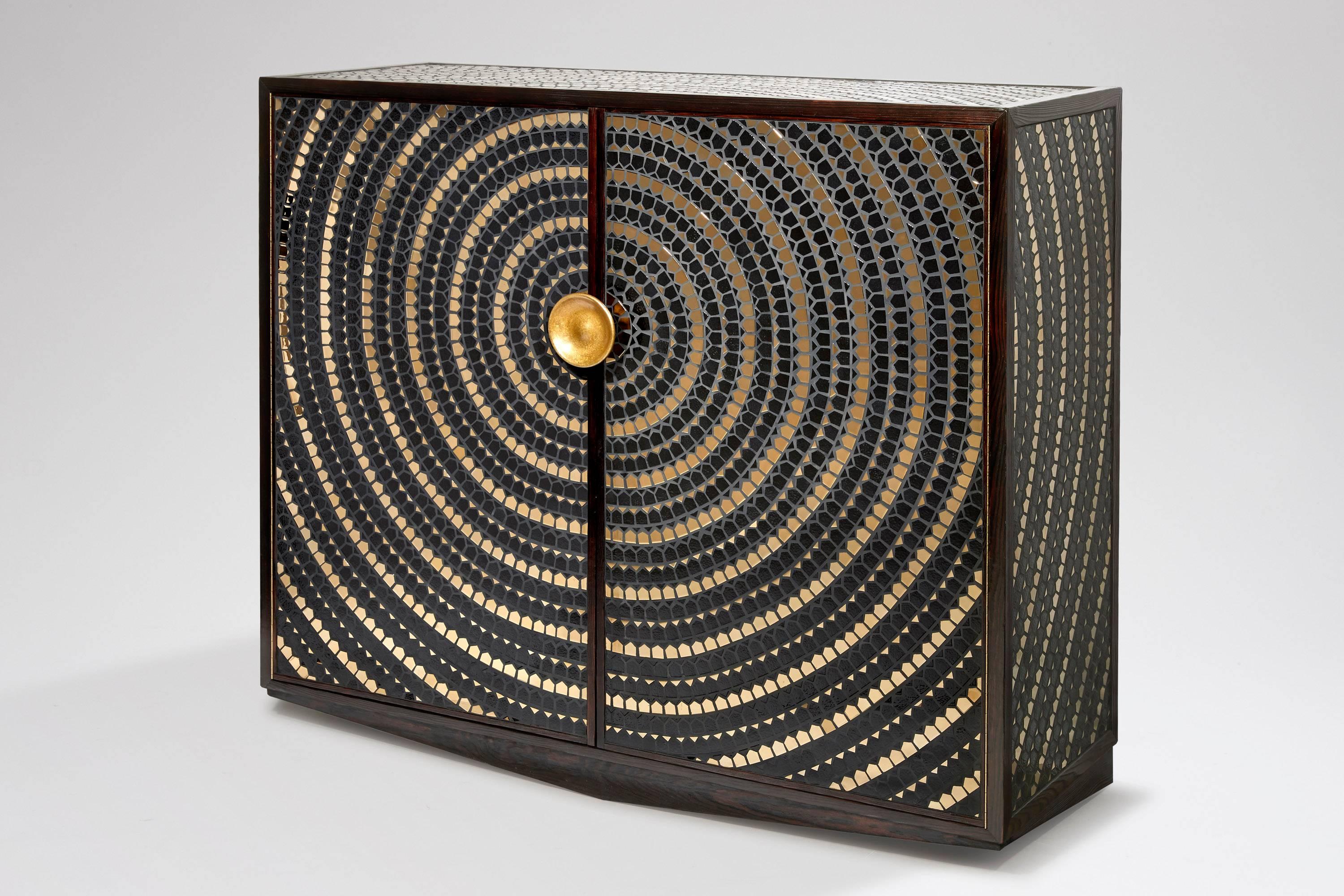A pinewood cabinet veneered with a mosaic of black and gold ceramic. 
The doors open onto an inside in oak fitted with shelves. The handle in bronze.
Stamped WH STUDIO.
Unique pièce.
 