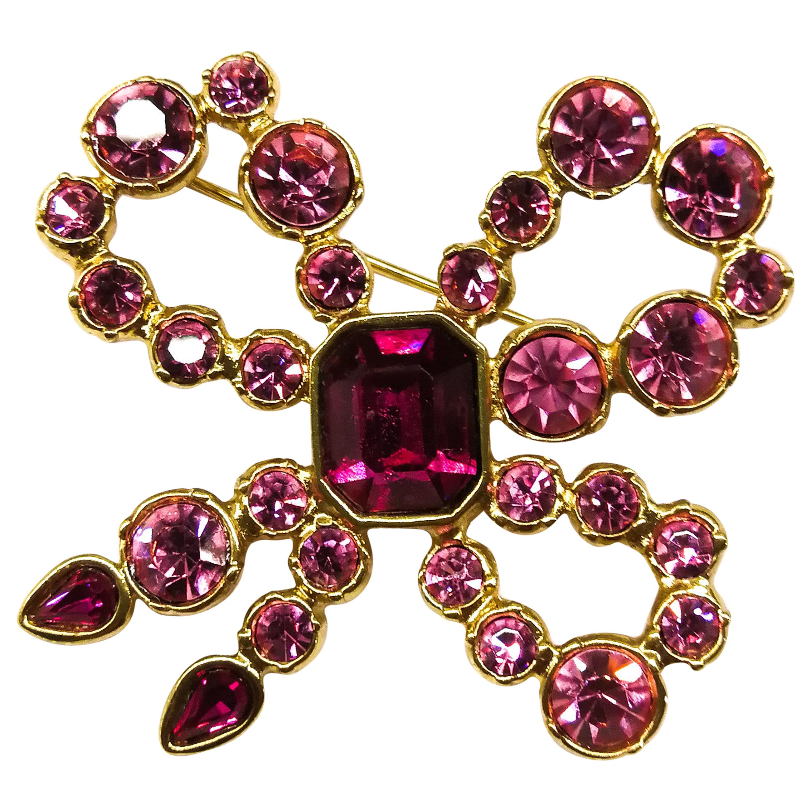 A pink paste and gilt metal 'bow' brooch, Yves Saint Laurent, France, 1980s