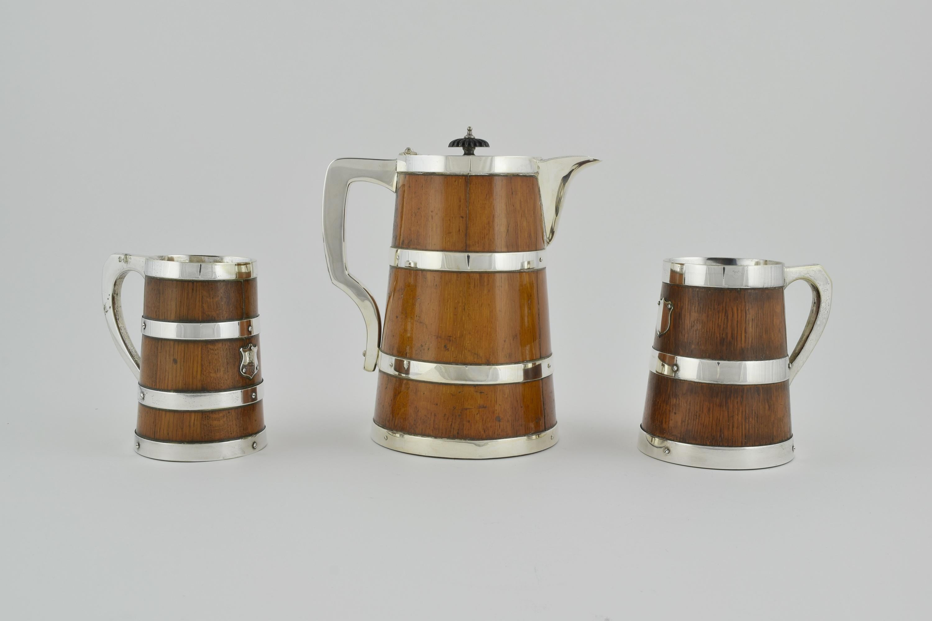 A Beer jug and two tankards whimsically formed as barrels.

 The interior of the jug is ceramic. Spout, handles and lid are made from silver plated nickel. The lid of the jug has an ebonized wood finial and is numbered on the inside, otherwise
