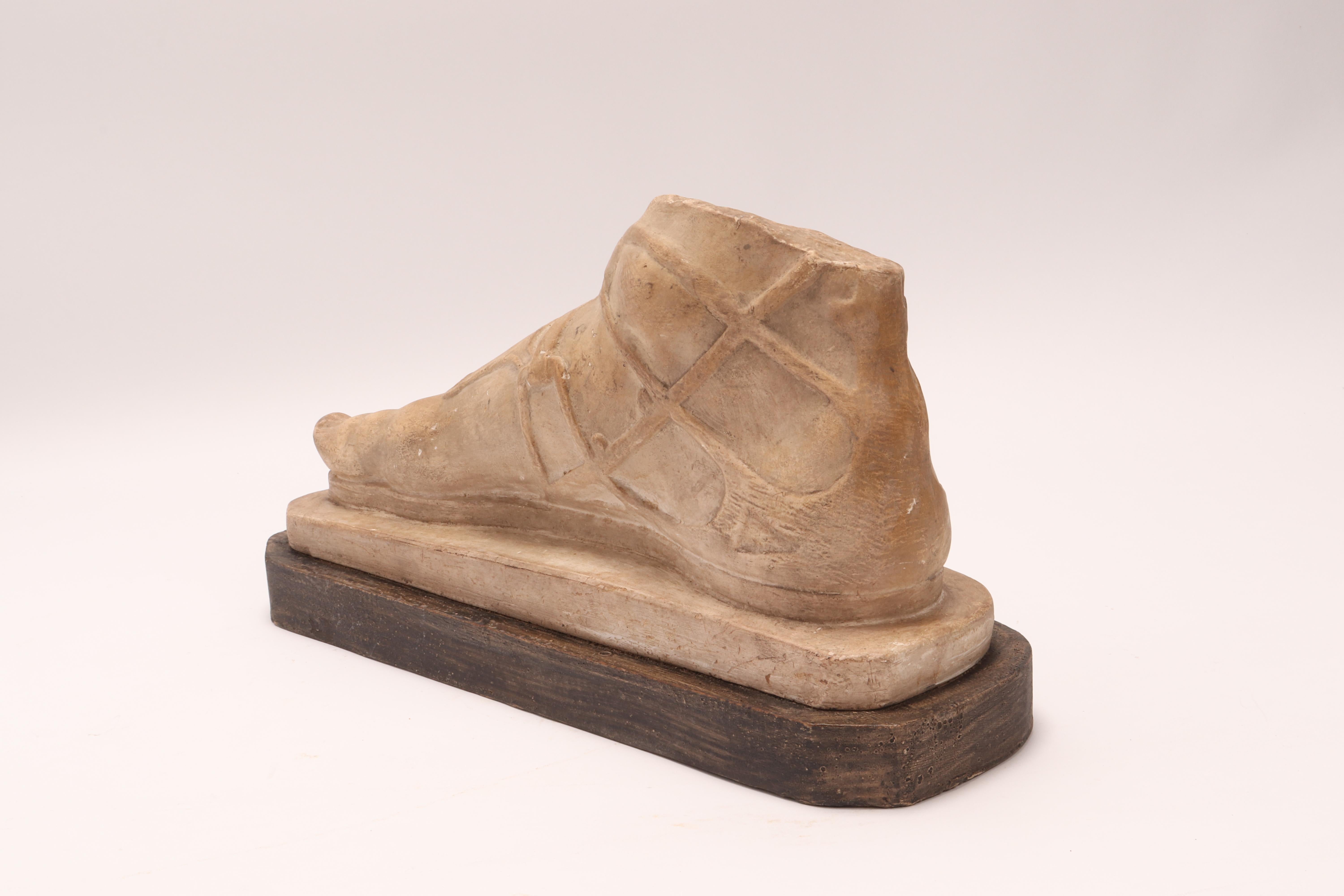 Over the wooden black painted base is set the plaster cast of the head of a Roman foot. The cast for drawing teaching in Academy. Italy, circa 1880.