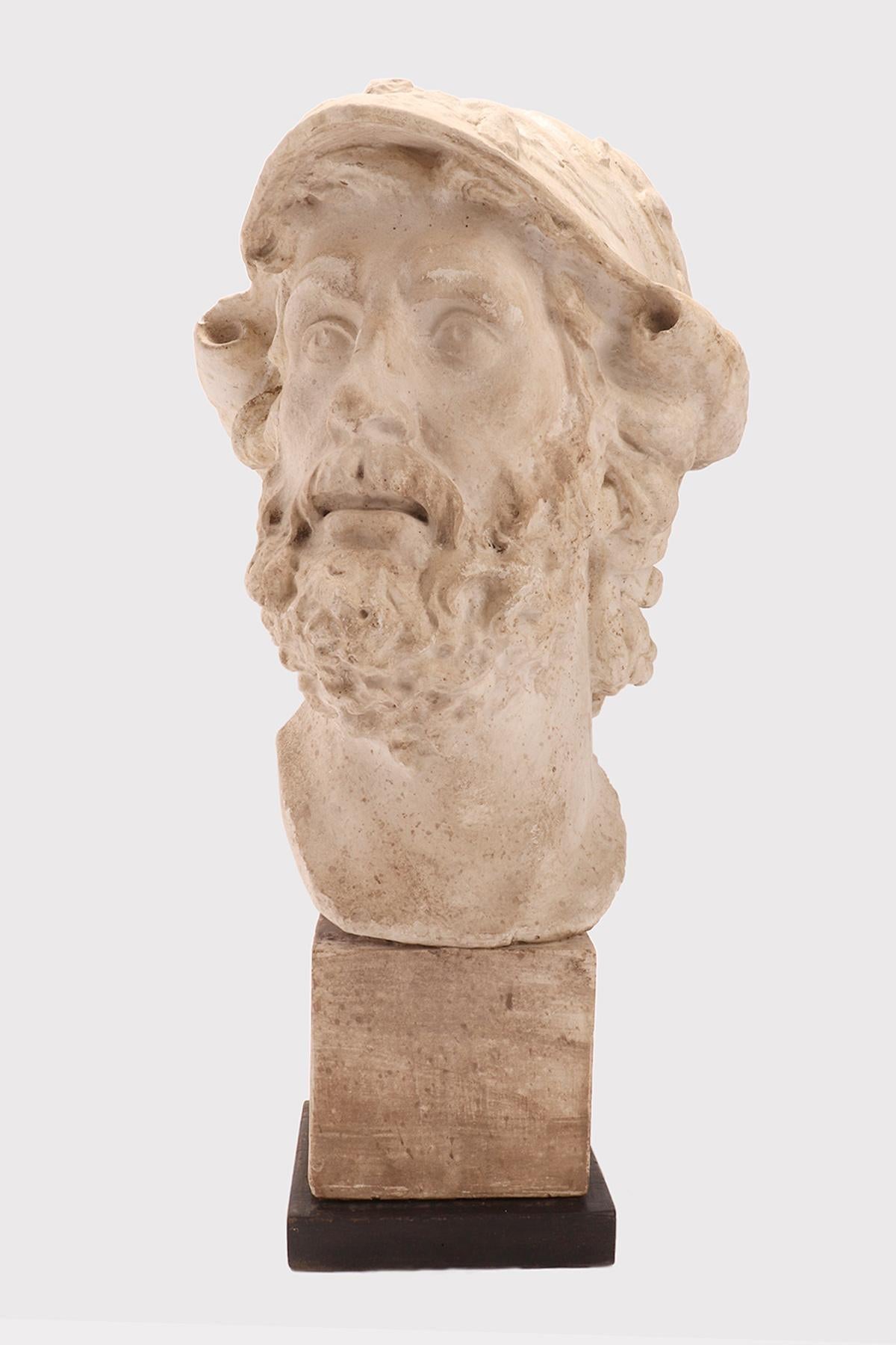 Sopra la base in legno di frutto dipinta di nero è incastonato il calco in gesso della testa di Menelao, II d.C. da un bronzo ellenistico. Getto per l'insegnamento del disegno in Accademia. Italia circa 1890. 