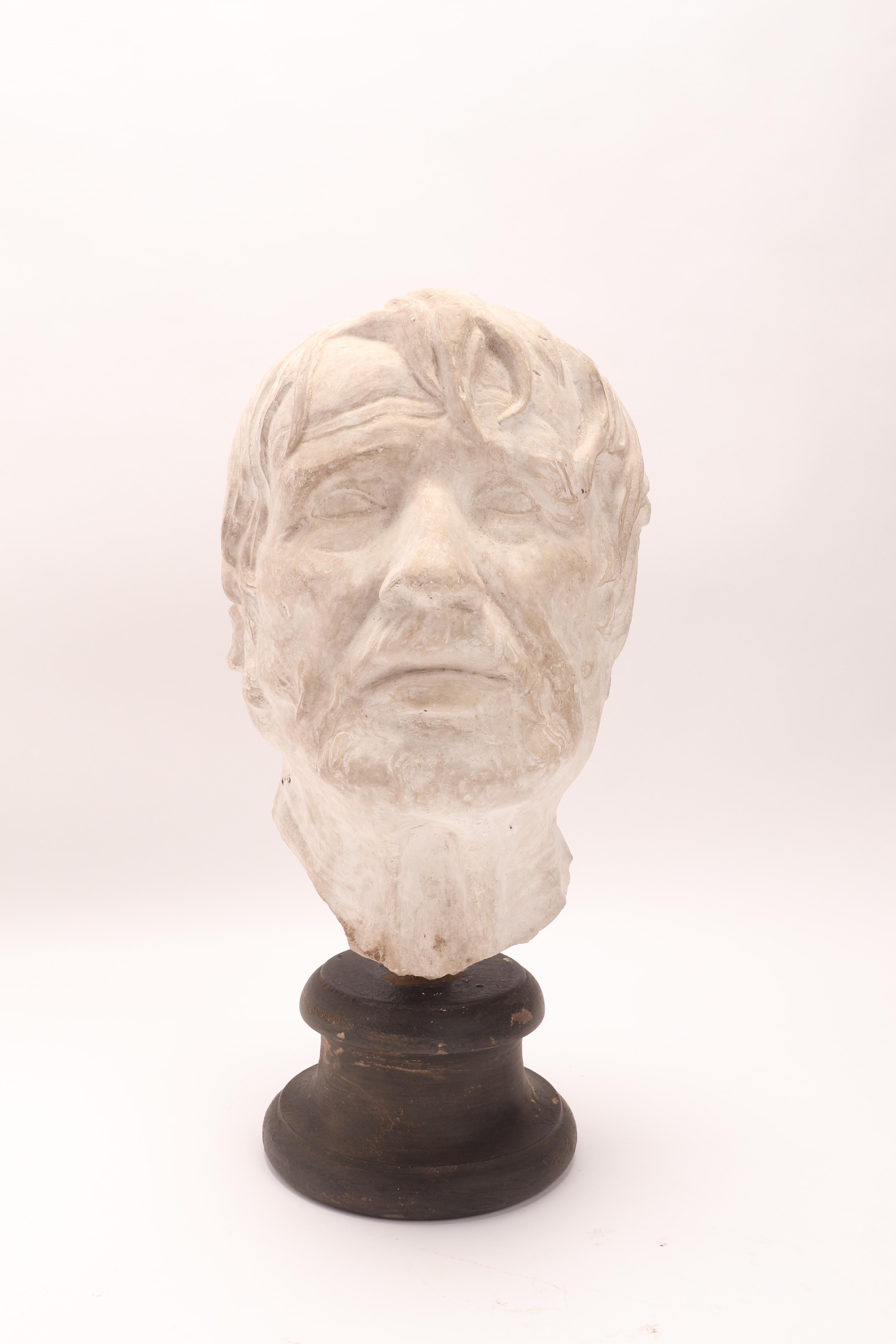 Over the wooden black painted base is set the plaster cast of the head of Seneca, from bronze from Ercolano, I Century a.C. The cast for drawing teaching in Academy. Italy circa 1890.