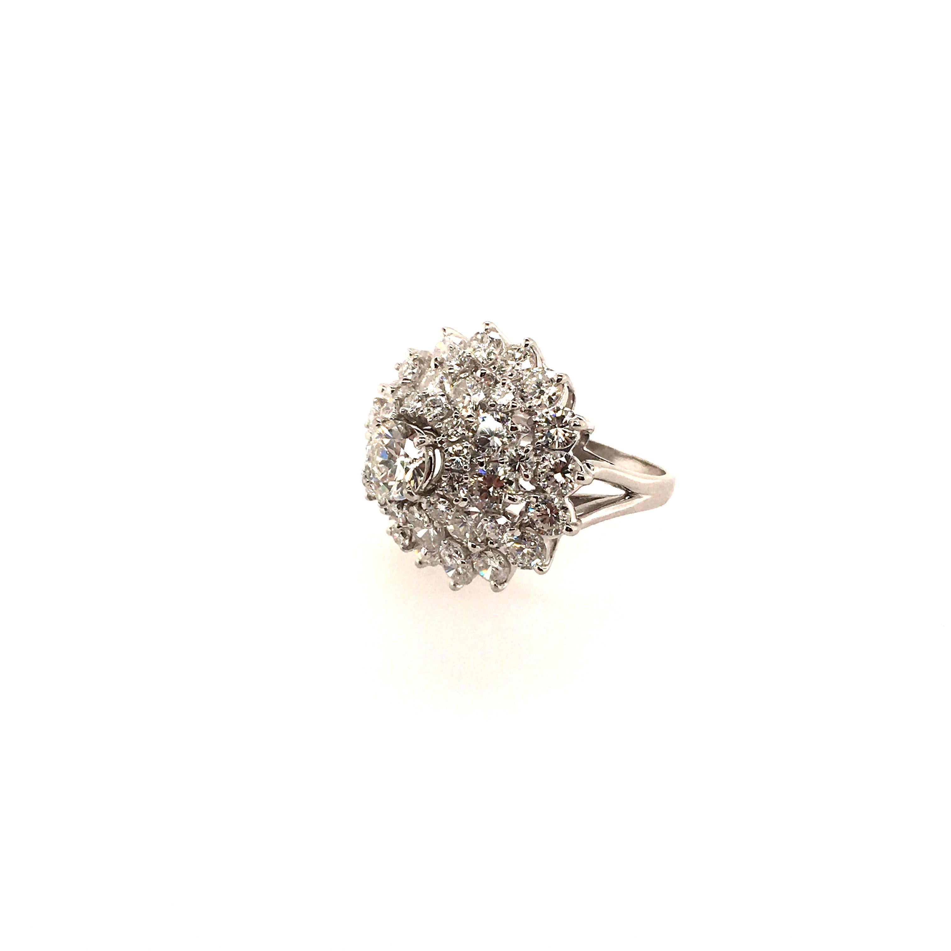 A platinum and diamond ring. Of cluster design, set with circular cut diamonds, centering a round brilliant cut diamond, weighing 0.89 carat, remaining twenty six (26) larger and twenty one (21) smaller diamonds weighing approximately 3.65 carats,