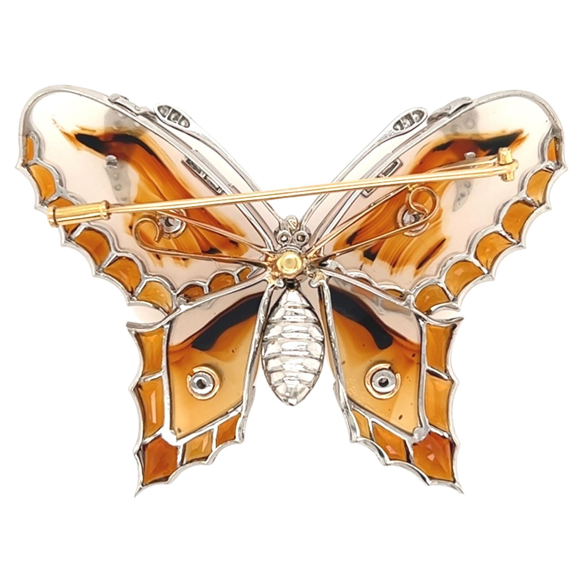 A platinum, 18 karat yellow gold, agate, citrine and diamond brooch, circa 1960s.  The brooch in the form of a butterfly with carved wings of translucent agate with brownish orange markings set in platinum with calibre cut citrines outlining the