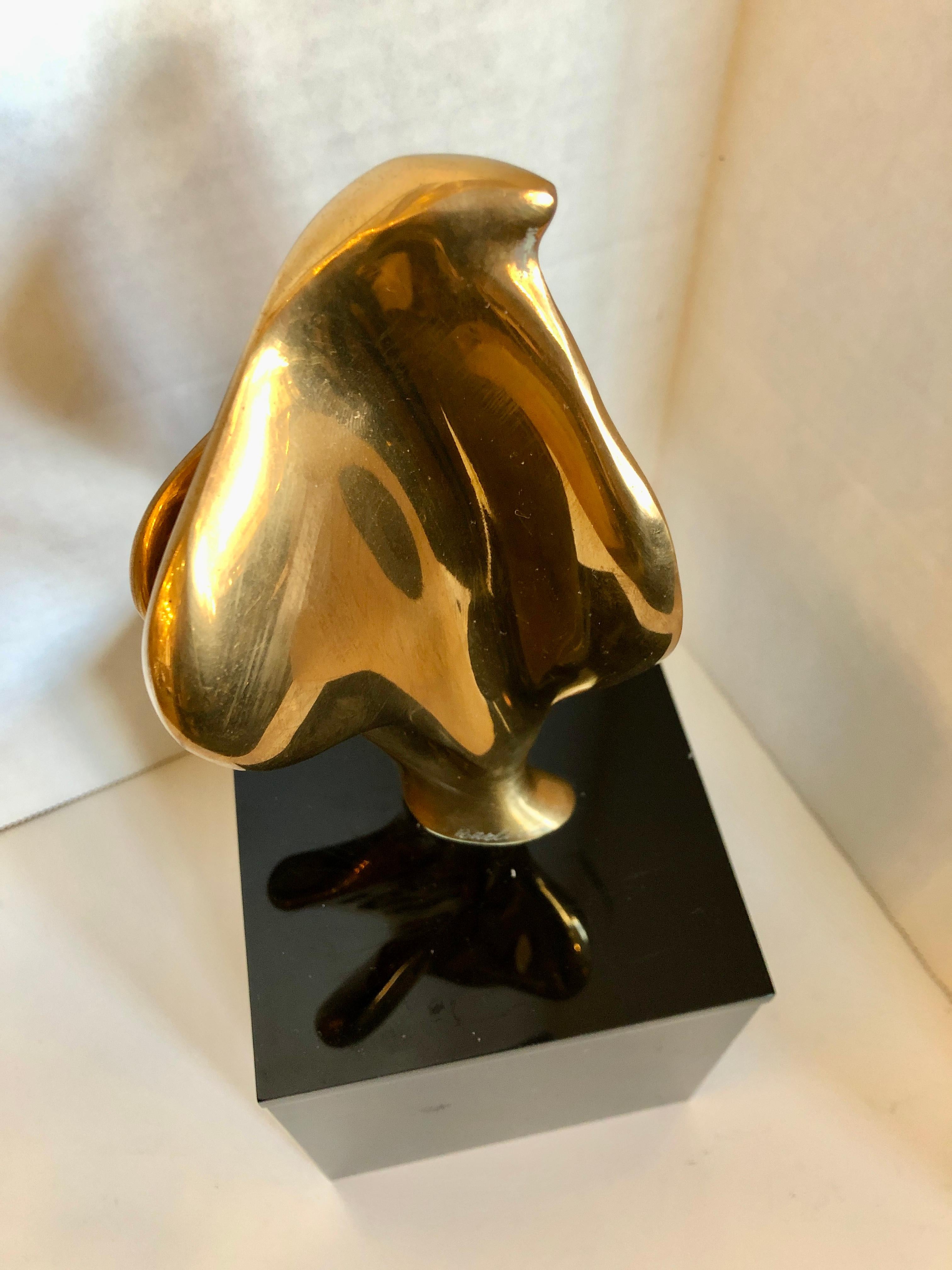 A Mid-Century Modern polished bronze biomorphic sculpture by Alfred Burlini raised on a black lucite base. Dated 1975 8/10.