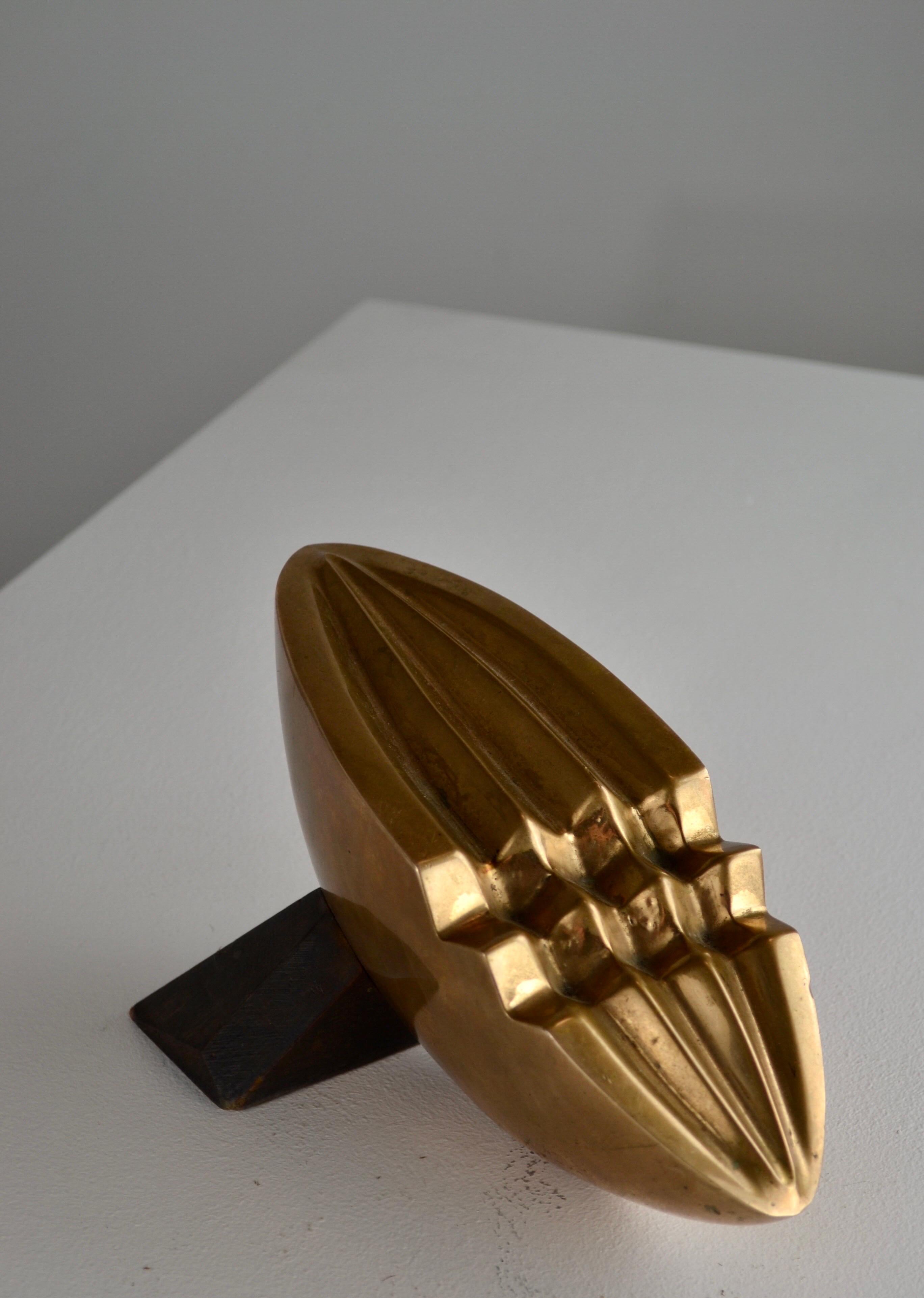Una magnifica scultura degli anni '30, nello stile delle opere di Brancusi. Questo pezzo notevole consiste in un mezzo cilindro in bronzo lucido, sostenuto da un pezzo di Oak intagliato e sfaccettato. La combinazione di bronzo lucido e rovere
