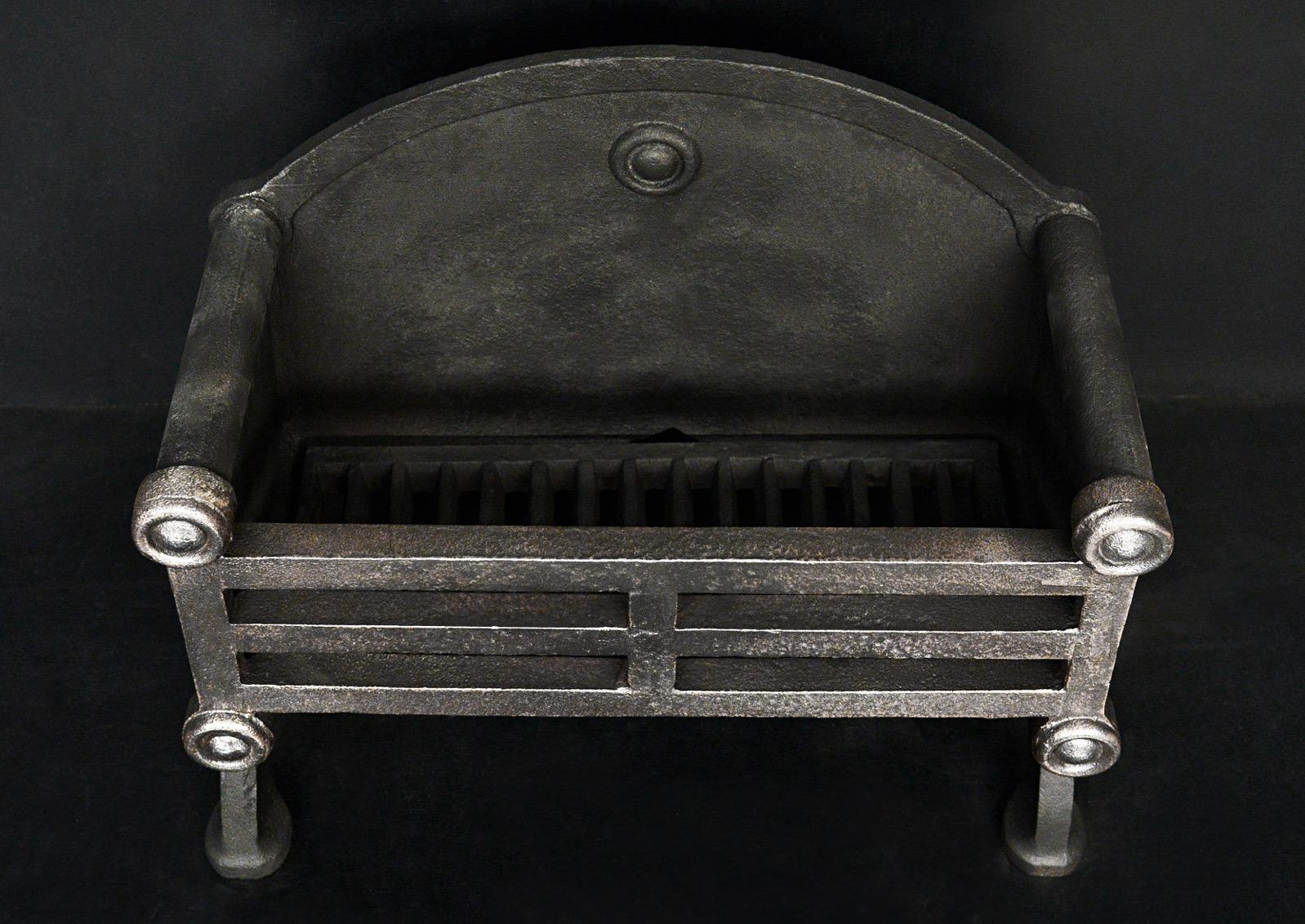 A small cast iron antique firegrate with round paterae to front and heavy geometric front bars. Shaped cast iron back behind with matching paterae. English.

Width At Front:	533 mm      	21