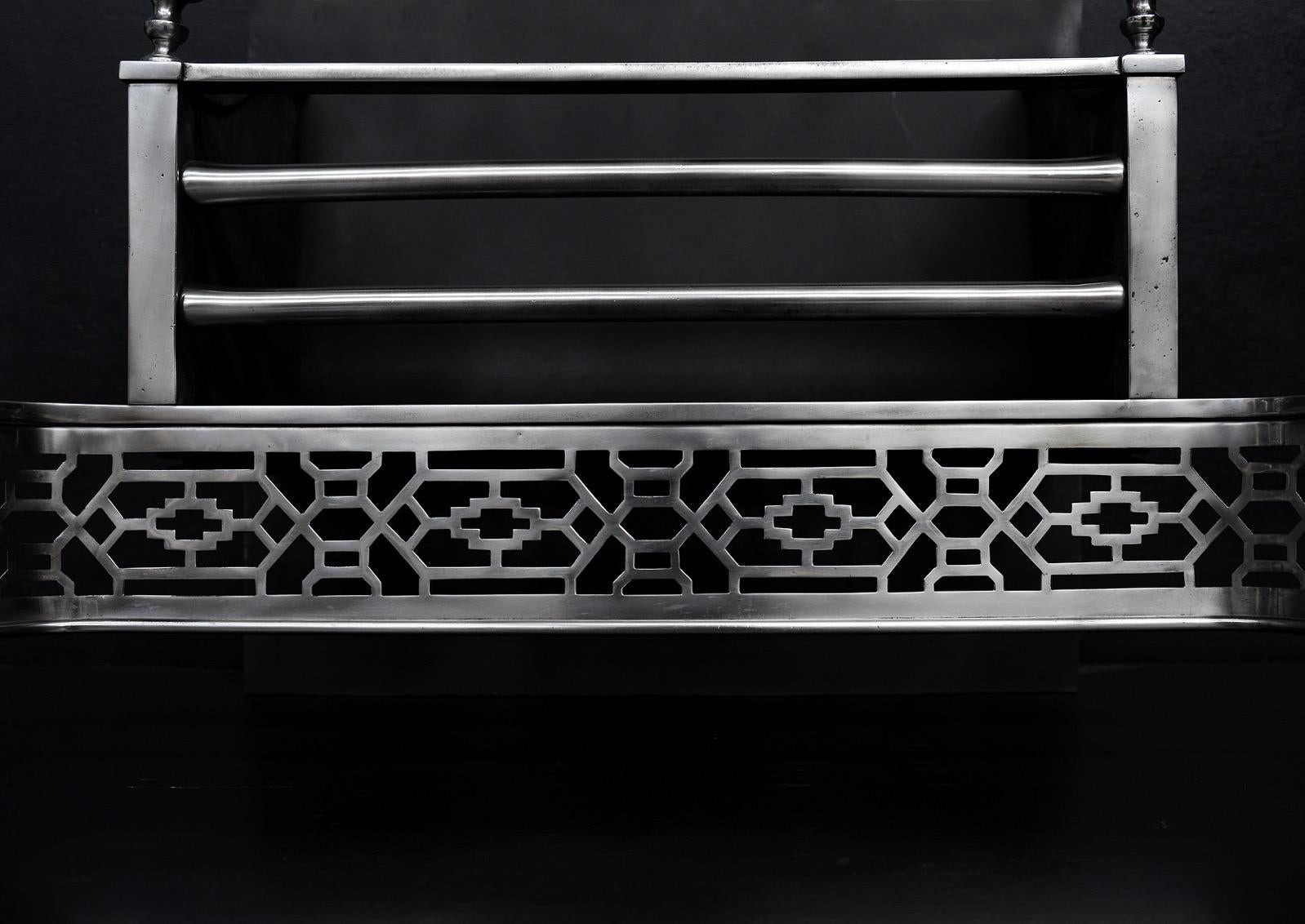 A polished steel firegrate in the Georgian style. The lattice fretwork flanked by scrolled legs with urn finals above. Straight front bars to burning area with plain fireback behind. English, circa 1900.

Width At Front:	750 mm      	29 ½