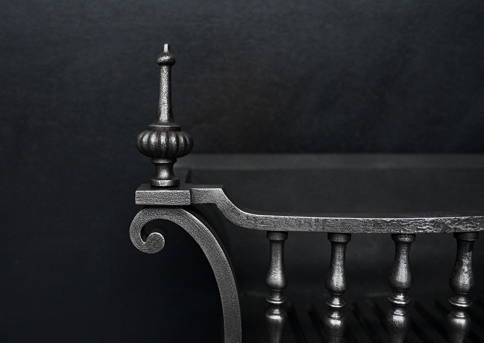 A polished wrought iron firegrate. The decorative legs surmounted by shaped uprights and gadrooned, classical finials. English, 19th century.  

Width At Front:	565 mm      	22 ¼