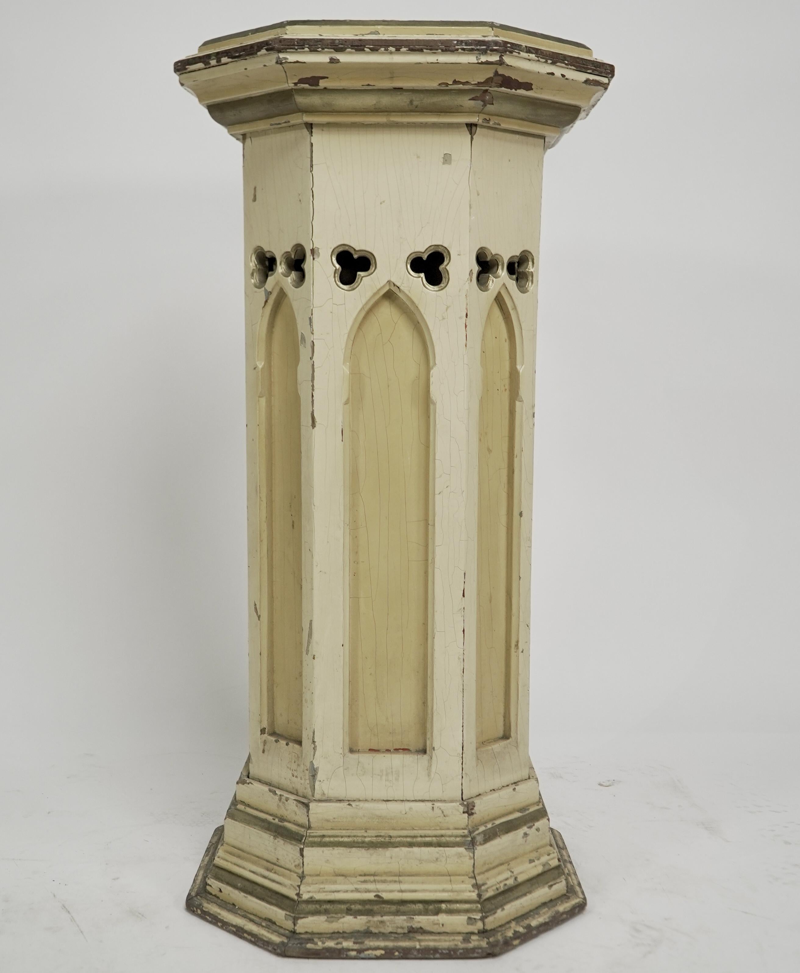 A Gothic Revival polychrome painted octagonal pedestal with a graduated molded edge to the top, below on five sides are pierced offset trefoils above each are blind carved Gothic arches, the other three sides are plain to go against the wall. The