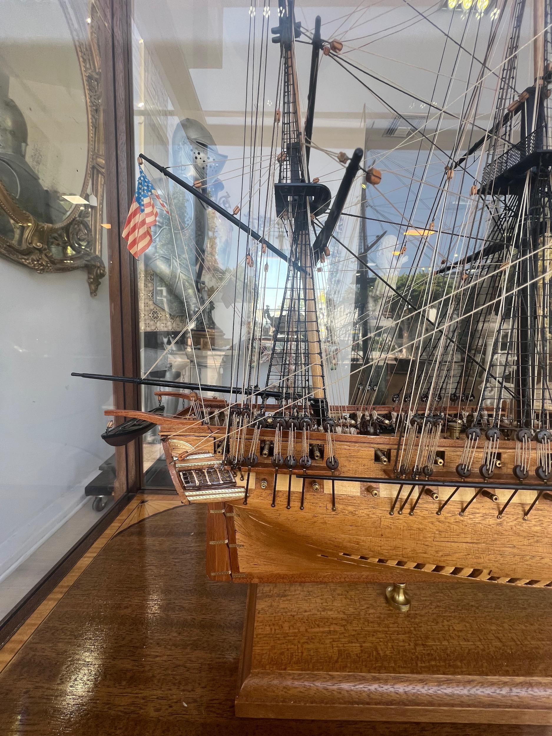 MODELLO DI NAVE POLICROMA DELLA FREGATA AMERICANA USS CONSTITUTION 'OLD IRONSIDES'
In una custodia in legno e vetro colorato.

altezza della cassa 32 1/2in (82,5cm); lunghezza 46in (117cm); profondità 19in (48,3cm)

I modelli di navi e le sculture