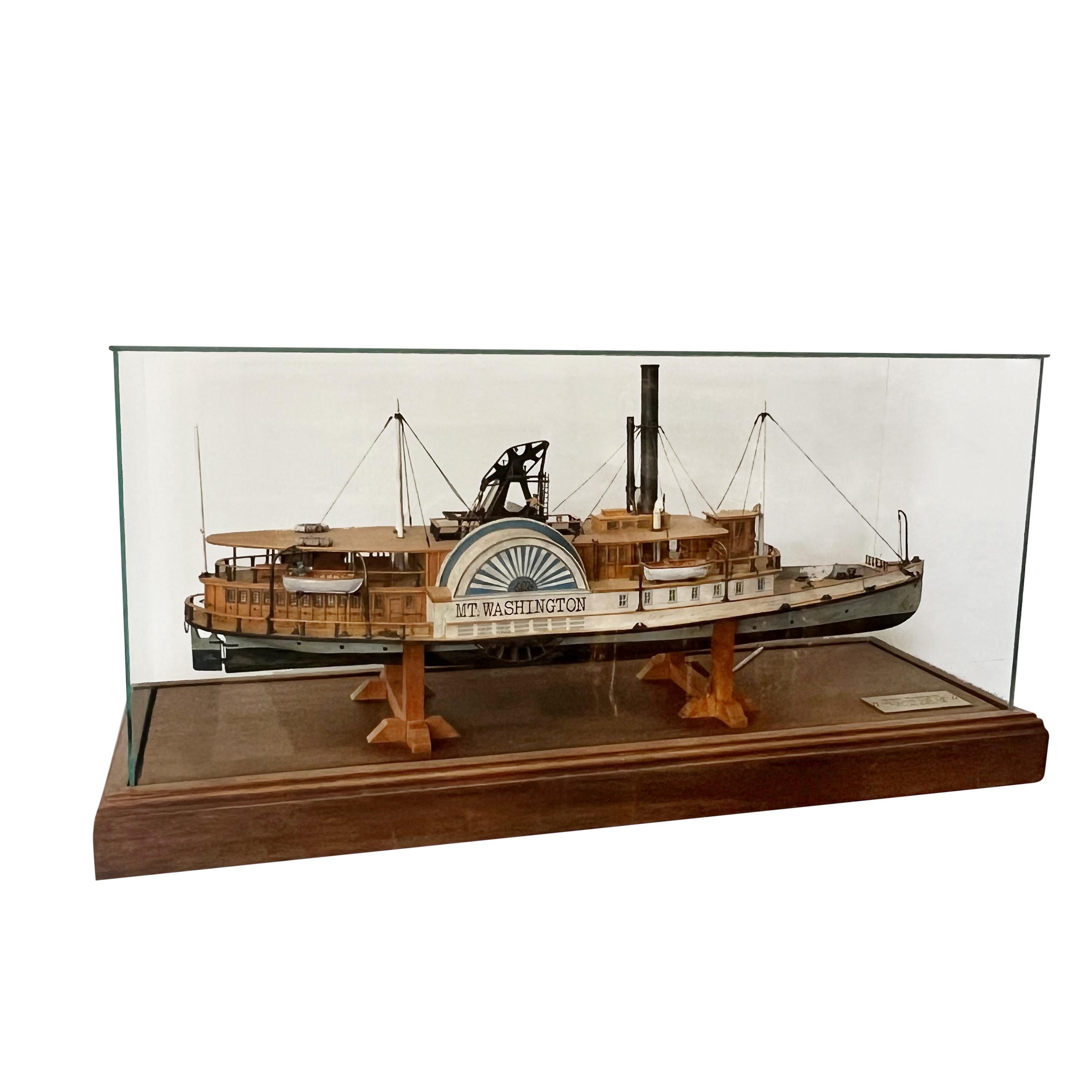 UNE MAQUETTE POLYCHROME DU BATEAU À VAPEUR MOUNT WASHINGTON
Modèle de F. Nagel, 1988
Dans un coffret en bois teinté et en verre avec une plaque portant l'inscription Mount Washington / Alton Bay Paddle Steamer of 1872 / model by F. Nagel ; 1988 /