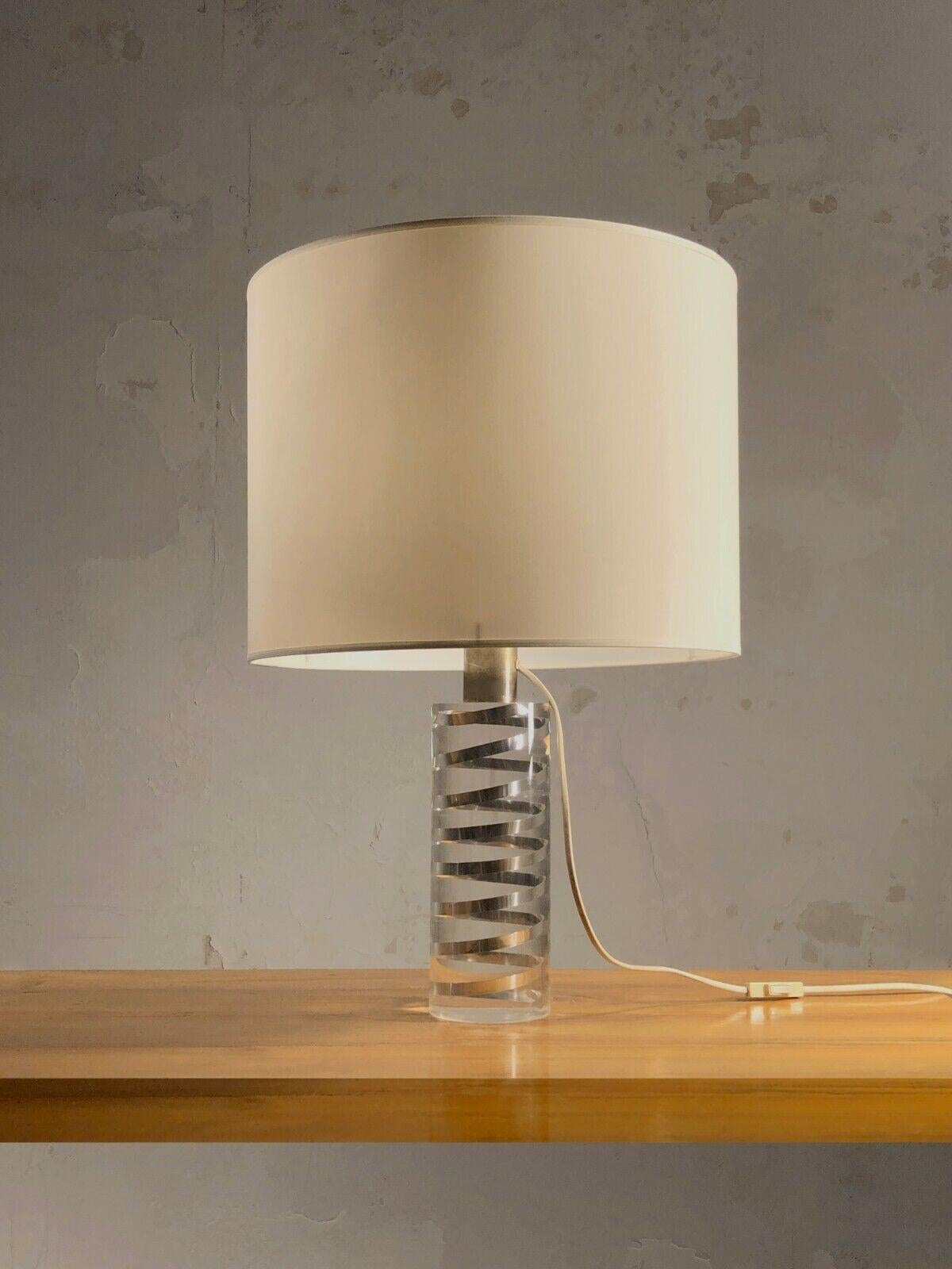 An important cylindrical table lamp, Post-Modernist, Seventies, Kinetic, Shabby-Chic, Pop, solid cylinder in transparent plexiglass including a metal spiral, attributed to Pierre Giraudon, France 1970.

SOLD WITH OR WITHOUT LAMPSHADES.
A SALE
