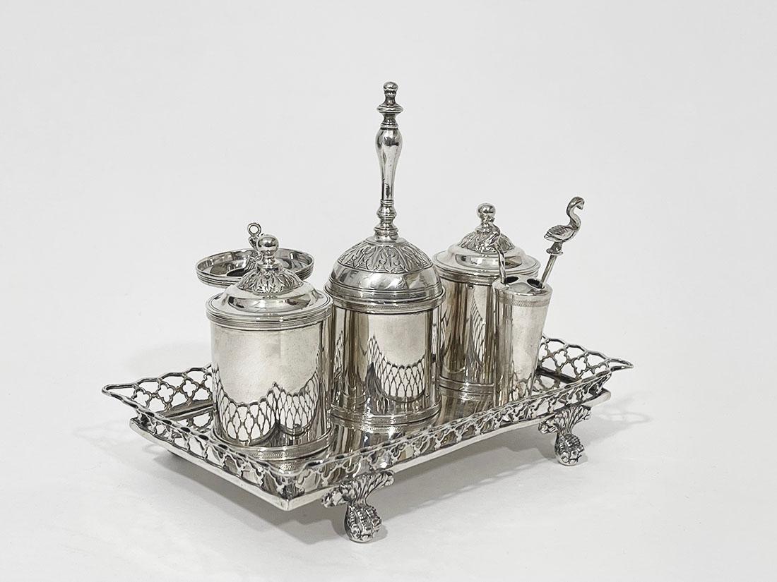 Encrier portugais en argent du début du XIXe siècle

Cet encrier en argent du début du 19e siècle se compose d'un plateau, reposant sur des pieds en forme de pattes avec une bordure ajourée, d'un porte-plume, d'un bougeoir, d'un encrier et d'un pot