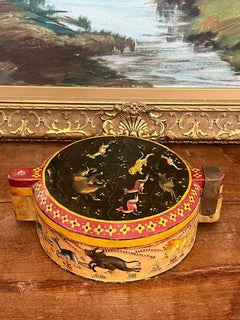 Una scatola decorativa rotonda laccata, probabilmente antica, con motivo floreale animale