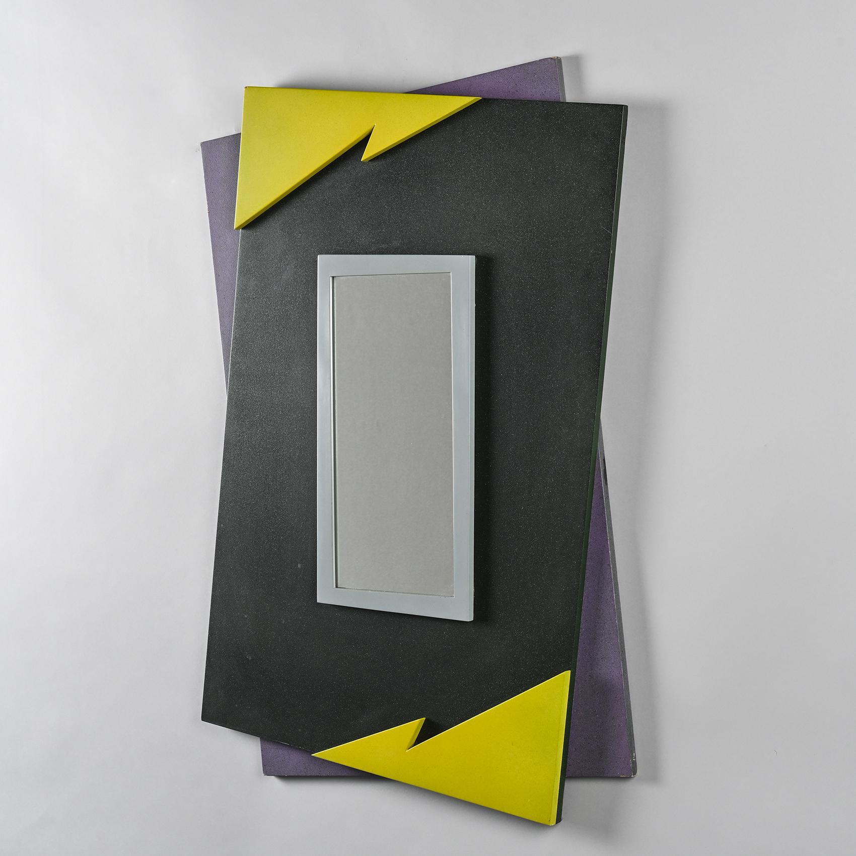 Ein Spiegel mit einem Rahmen aus laminierter Spanplatte in einem kühnen 80er-Jahre-Design mit schwarzen, gelben und schwarz-violett gesprenkelten Mustern.

Auf der Rückseite mit der Unterschrift von Mario Eichmann und dem Namen des Herausgebers