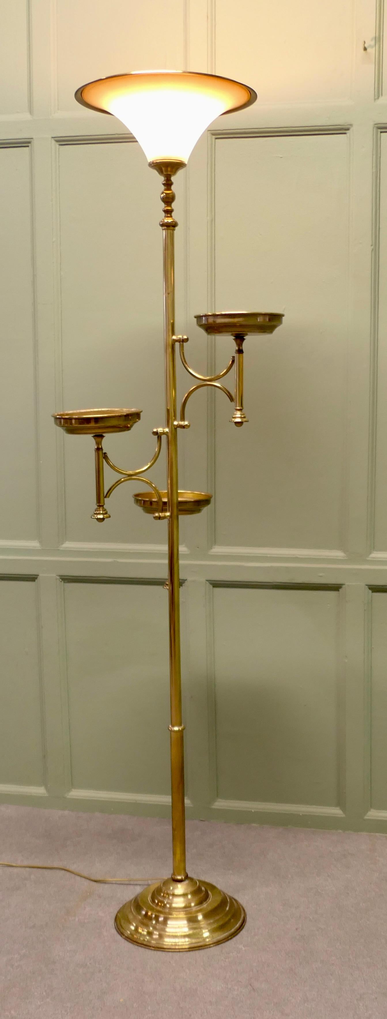 A Postmodern Floor Lamp with 3 Plant Stands

This is a beautifully designed and very practical piece, the lamp has a heavy brass base which supports a brass column this has 3 elegant brass plant saucers alternated around it leading up to an uplight