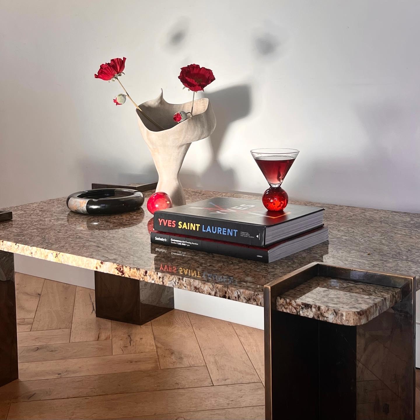 A stone coffee table upheld by four steel supports, attributed to Leon Rosen for PACE Collection, circa 1970. Tones of caramel, sand, and pewter. Wear is minor and includes a hairpin fissure in the surface of the stone (see photos). Pick up in