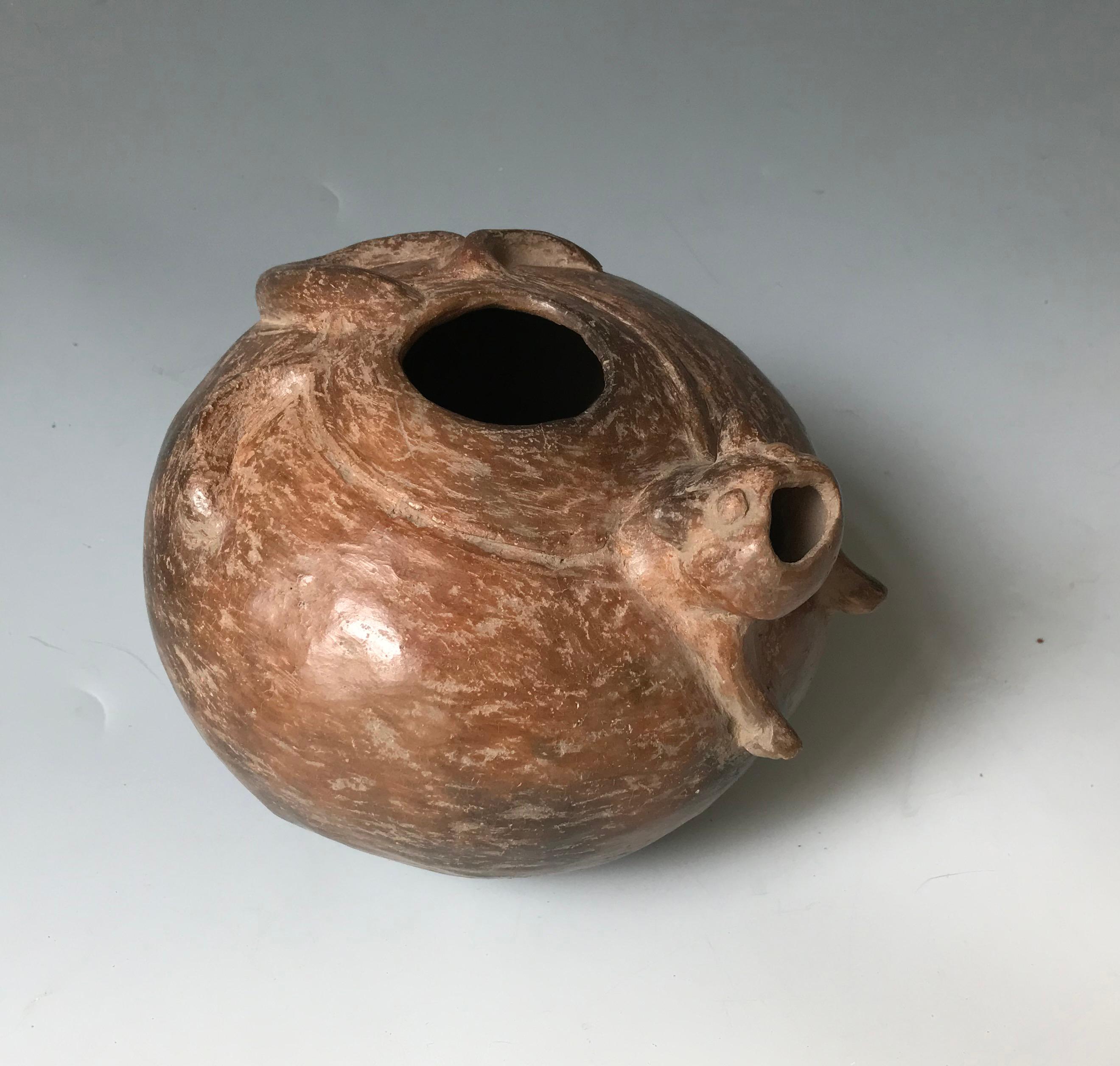 A Pre Columbian Chorrera Bahia vessel
A attractive finely made round pottery bowl in brown clay featuring a splayed animal on top, probably representing a Feline, the head with open mouth acting as a spout.
Chorrera Bahia transitional period circa