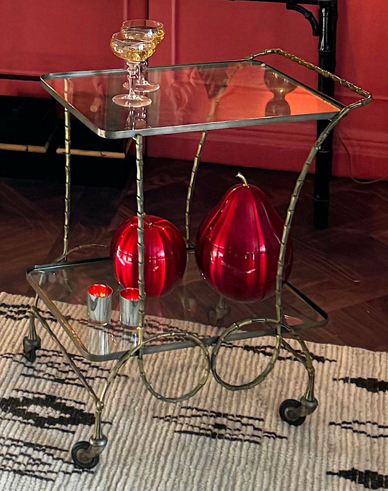 Grazioso carrello da bar francese degli anni '50 in ottone massiccio in finto bambù di Maison Baques con due ripiani in vetro e struttura decorativa a vortice su rotelle in ottone originali con gambe decorative.