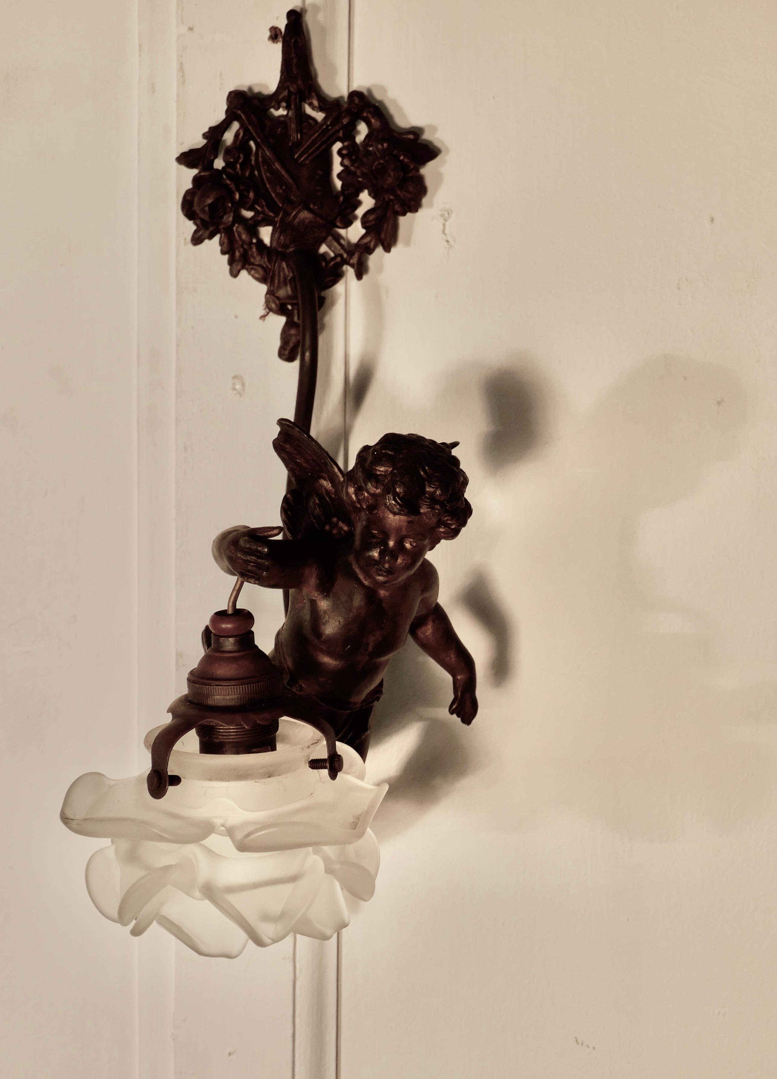 A pretty French ormolu cherub wall light

This is a pretty piece, it is made in ormolu and age darkened brass, and has a pretty opaline glass flower lamp shade, the cherub or putti hangs from an elaborated wall plate and the lampshade is hanging