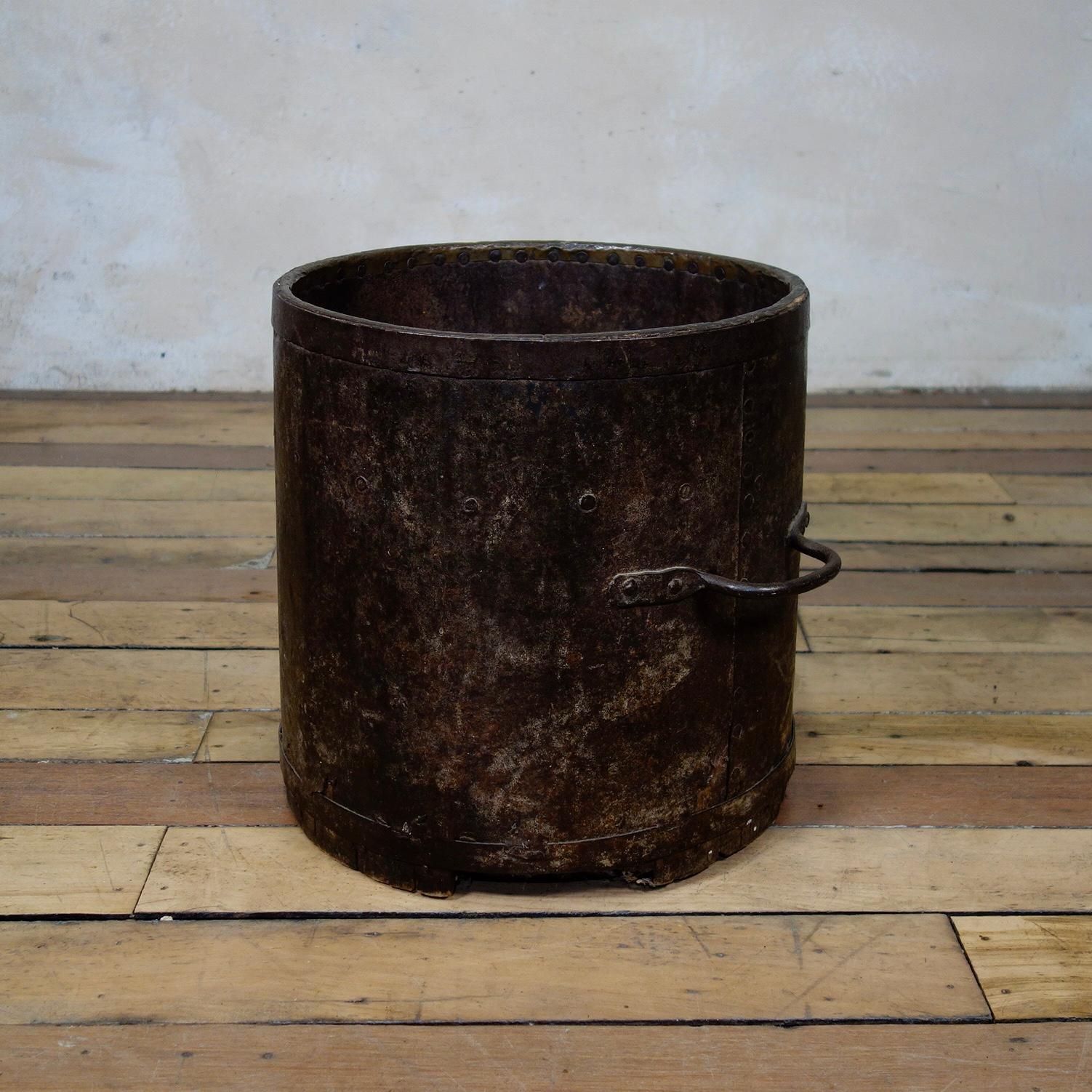 A Primitive 19th century bushel barrel, measuring vessel, originally used for measuring consistent quantities of agricultural products such as wheat. Displaying iron handles and bindings, a striking accent piece for a casual