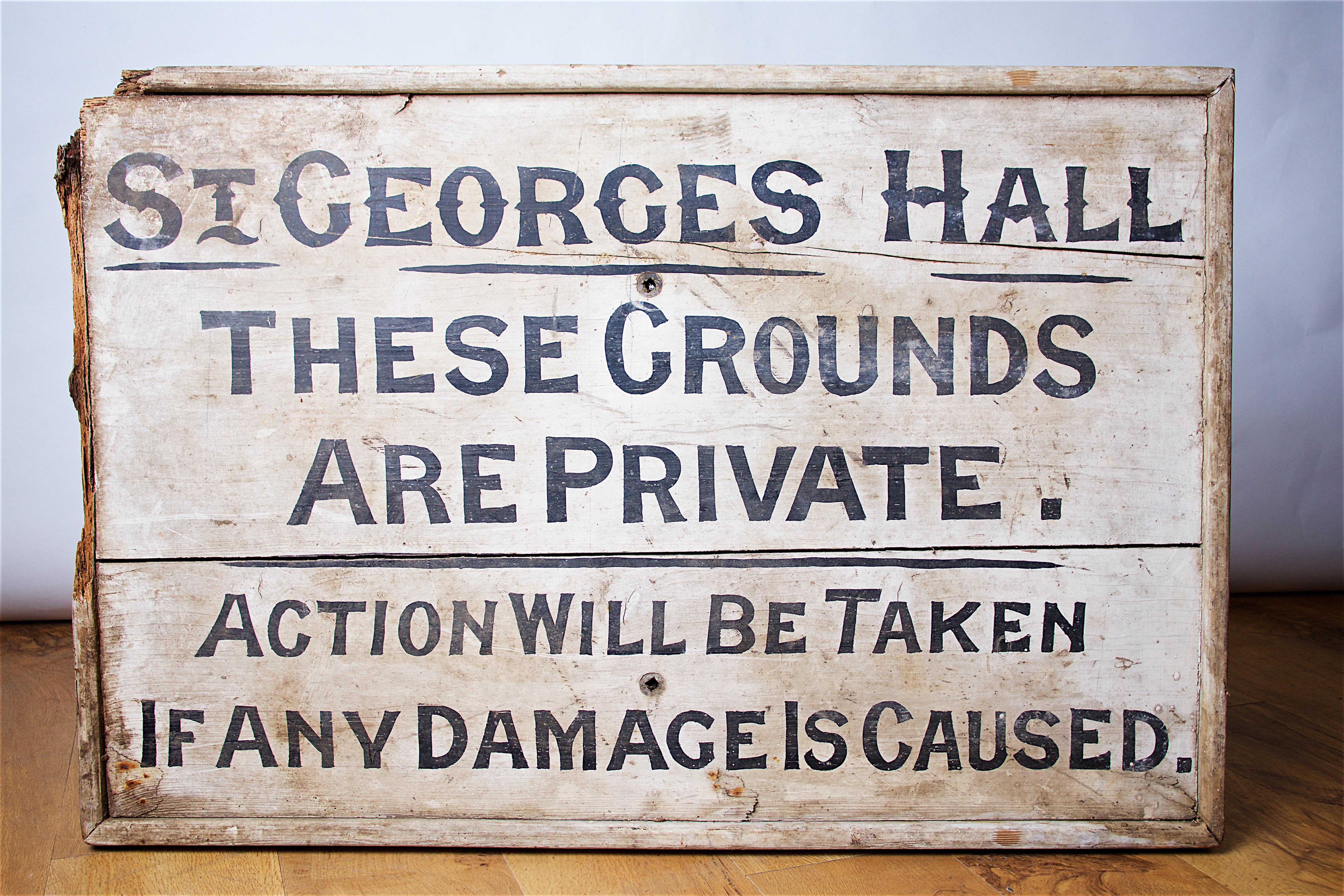 A circa late 19th century hand painted wooden sign, black writing on white background, bearing the legend “St. George’s Hall – these grounds are private, action will be taken if any damage is caused”.
