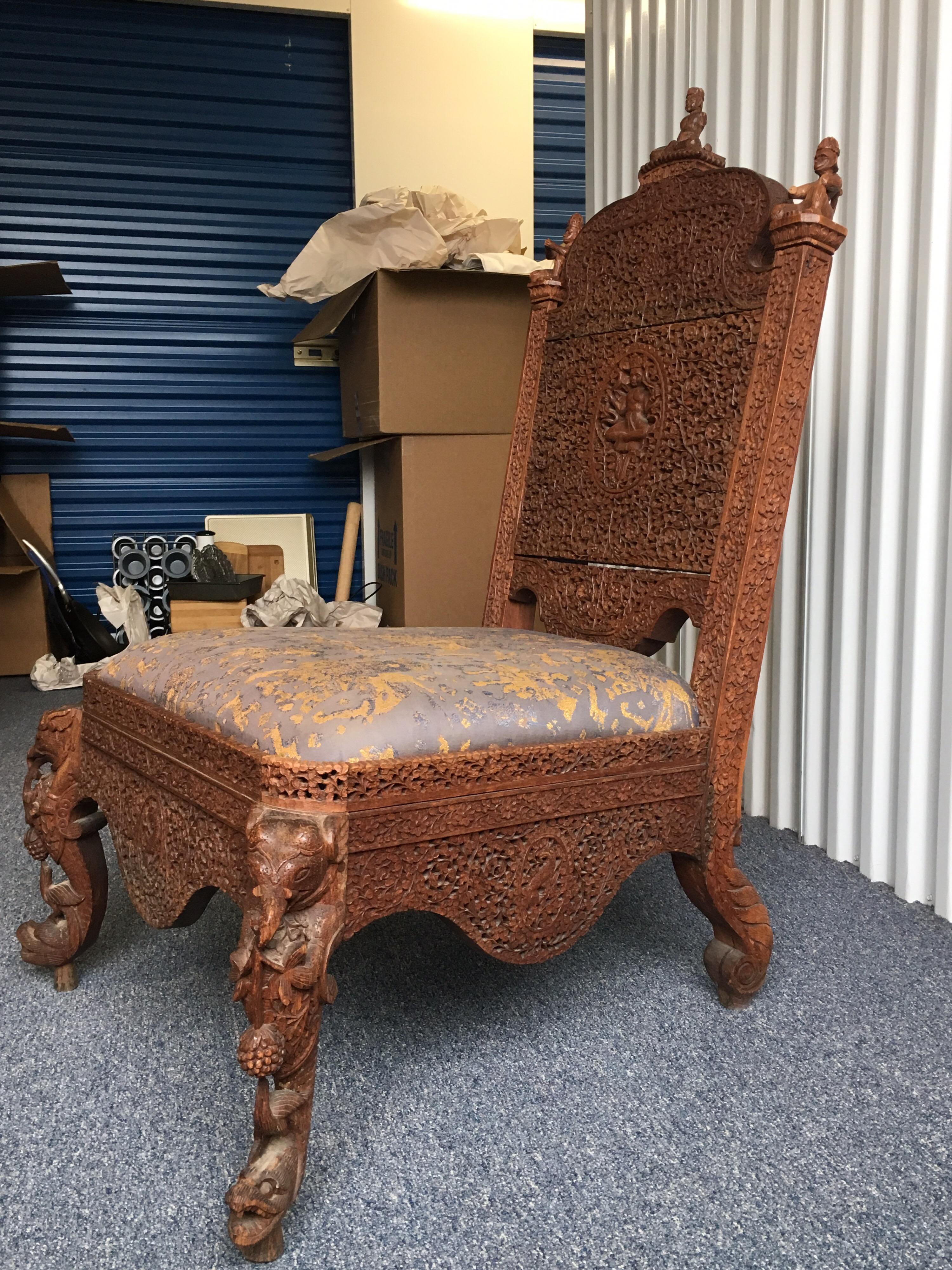 A profusely pierced carved Indian rosewood low side chair, circa 1880.

A profusely pierced carved Indian rosewood side chair, the shaped top rail decorated with three seated deity figures, the back profusely pierced carved with a central seated