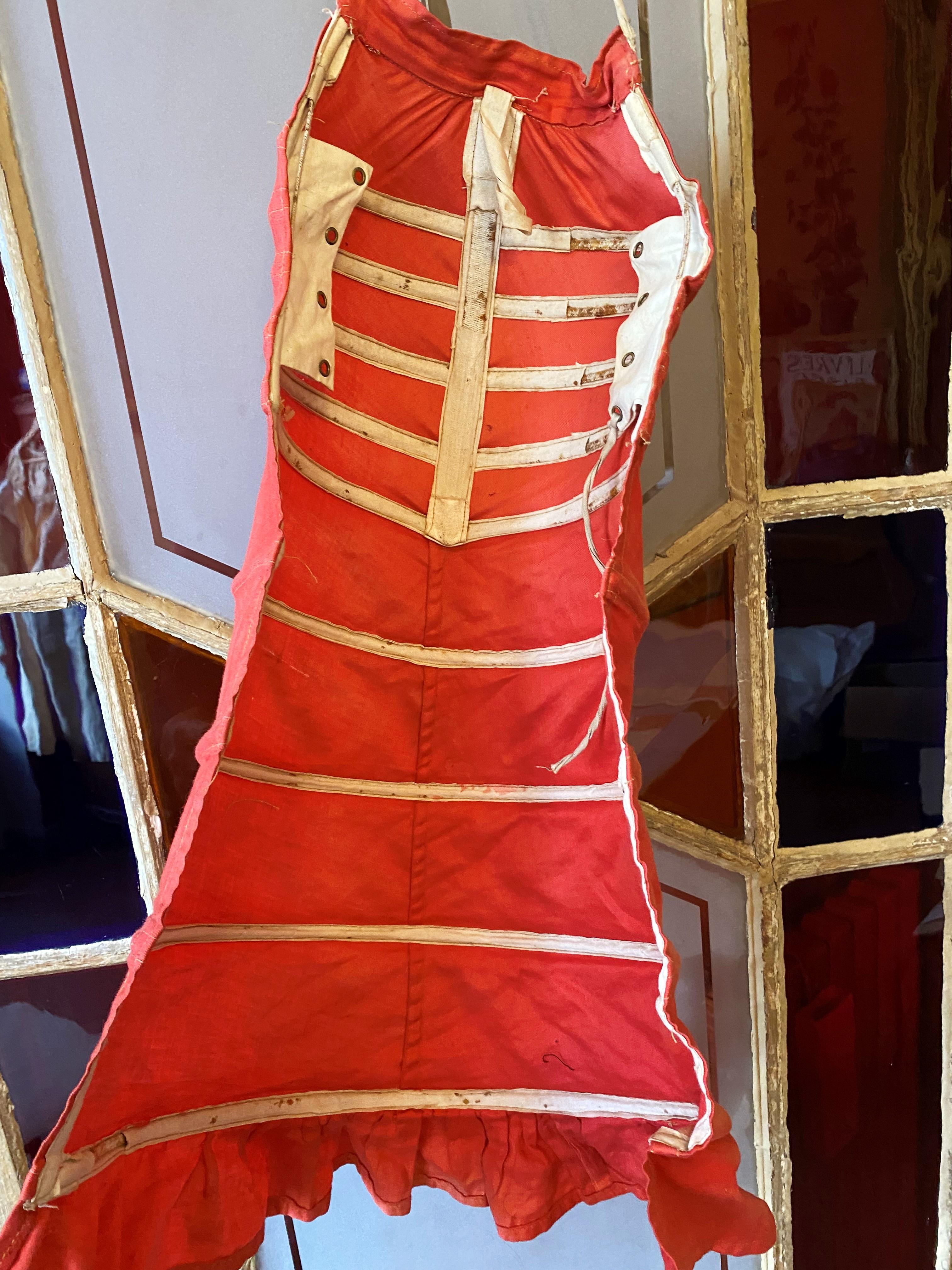 Circa 1875 - 1895
France or Europe

Small Bustle cage to refine the Silhouette called Queue d'écrevisse in scarlet cotton twill dating from the late 19th century. Nine metal hoops covered with cotton. Legs with eyelets and cotton ties (one replaced