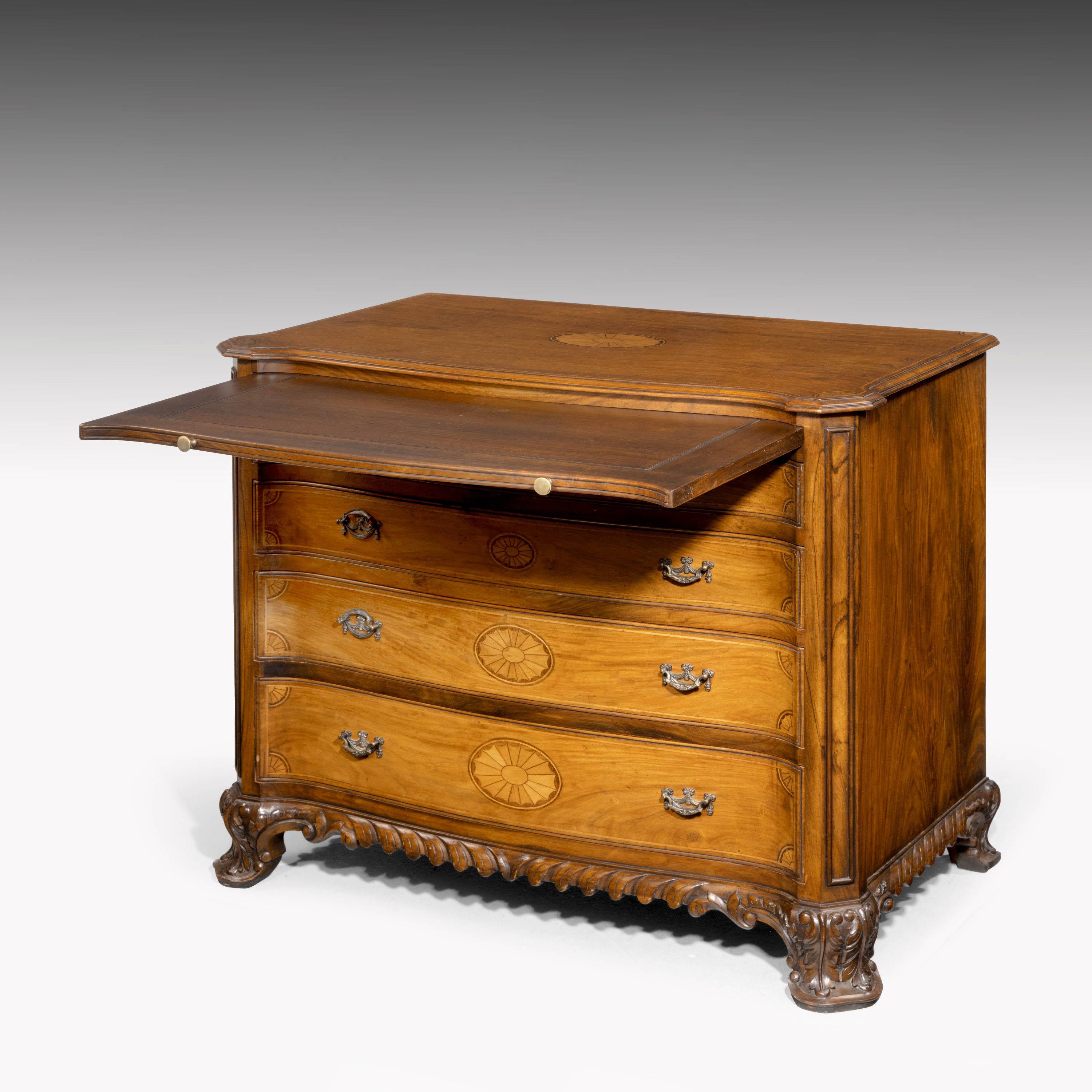 A quite exceptional serpentine fronted mahogany commode of the finest quality. With canted corners and sunburst inlays to the top and the drawer fronts. Original cast gilt bronze handles and incorporating a dressing slide. The bottom mold