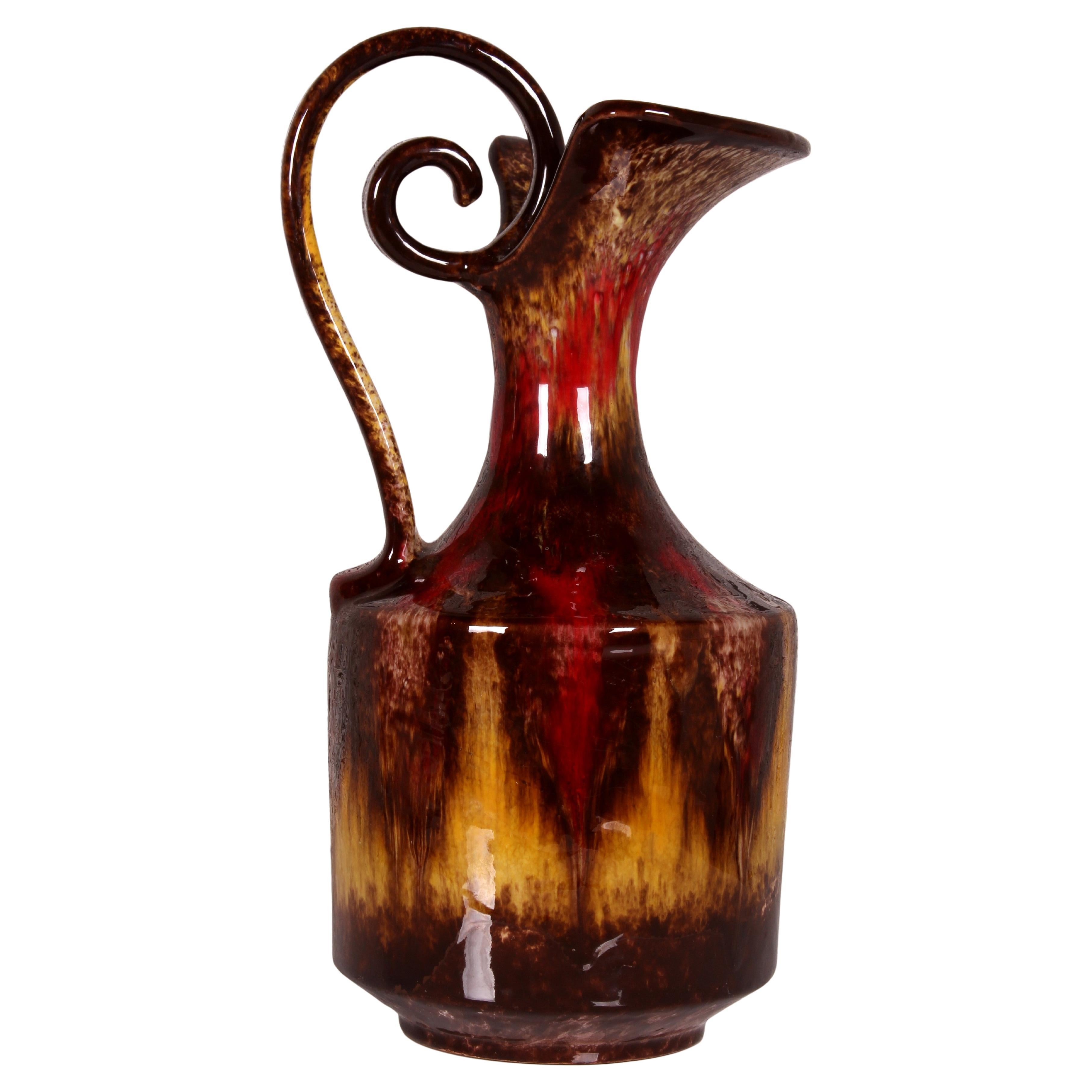 Il s'agit d'un exemple exceptionnel de design et d'artisanat italiens. 

Le vase à anse en forme de cruche semble d'abord être composé de verre. Un examen plus approfondi révèle que l'objet est en fait un exemple caractéristique de poterie tachetée