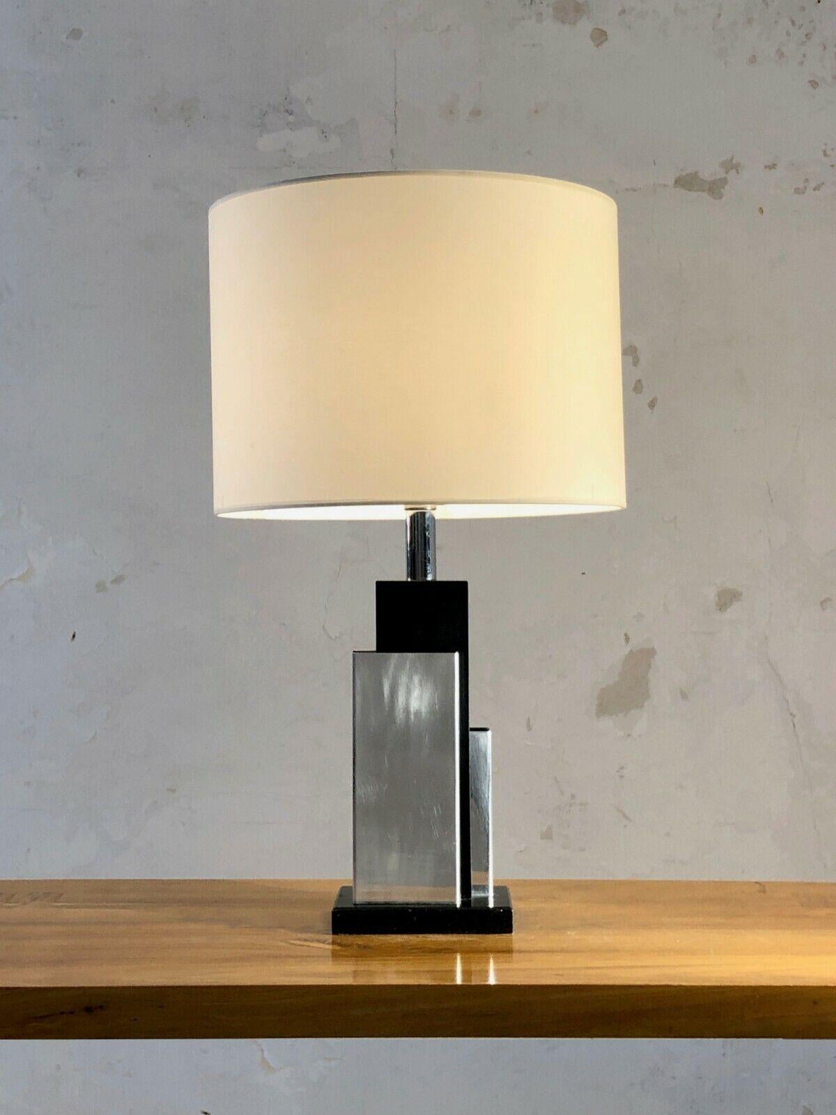 A radical architectural table lamp, PostModern, Modernist, Constructivist, Cubist, Memphis, in black lacquered wood with asymmetrical chrome metal decoration, in the spirit of Willy Rizzo, to be attributed, France 1970.

SOLD WITH OR WITHOUT