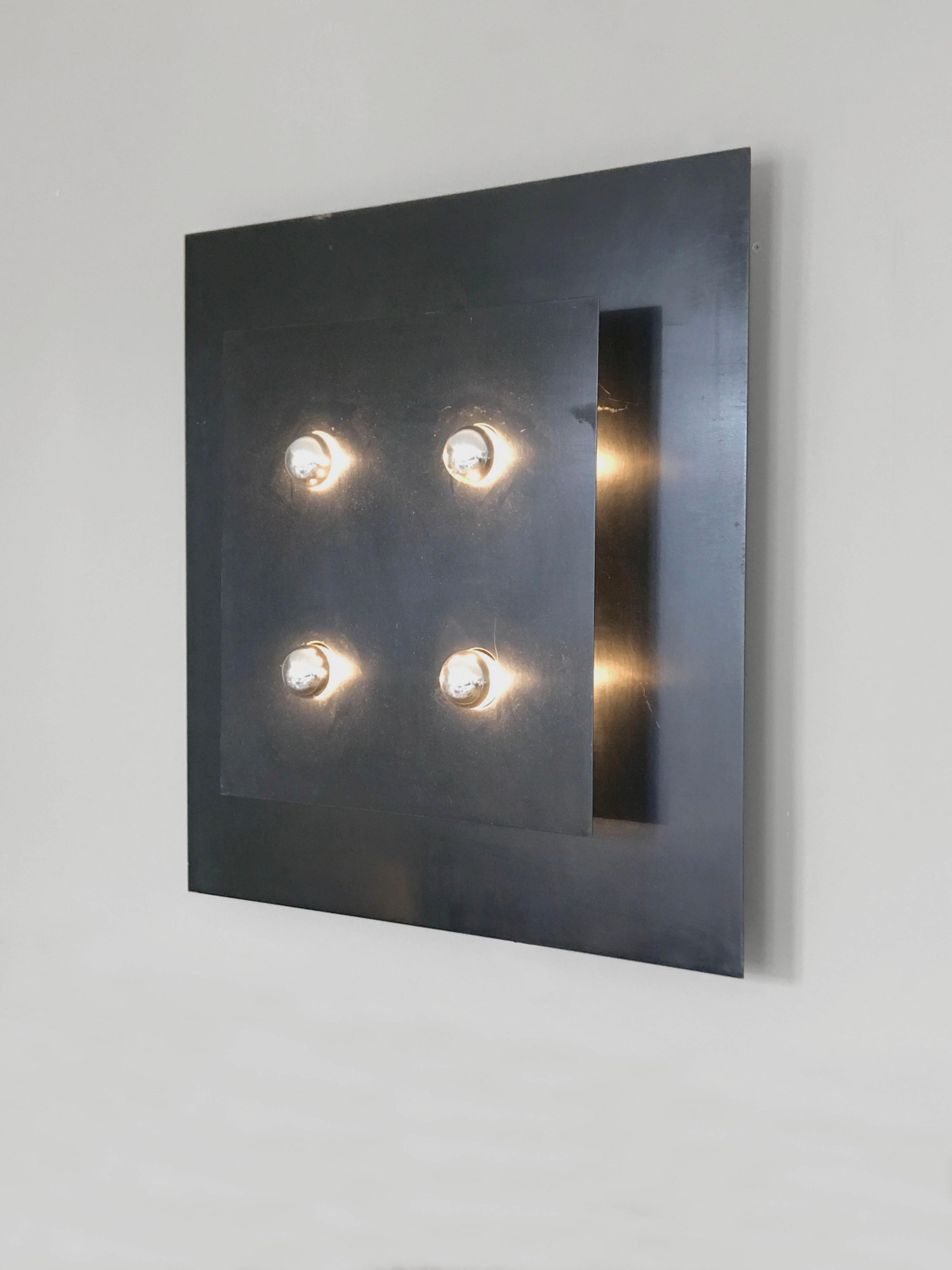 An authentic and important wall applique Radical, Post-Modernist, Minimalist, consisting in 2 superposed squares perforated by 4 circular openings allowing 4 indirect lightnings. This is a abstract geometric lighting sculpture, one of the very rare