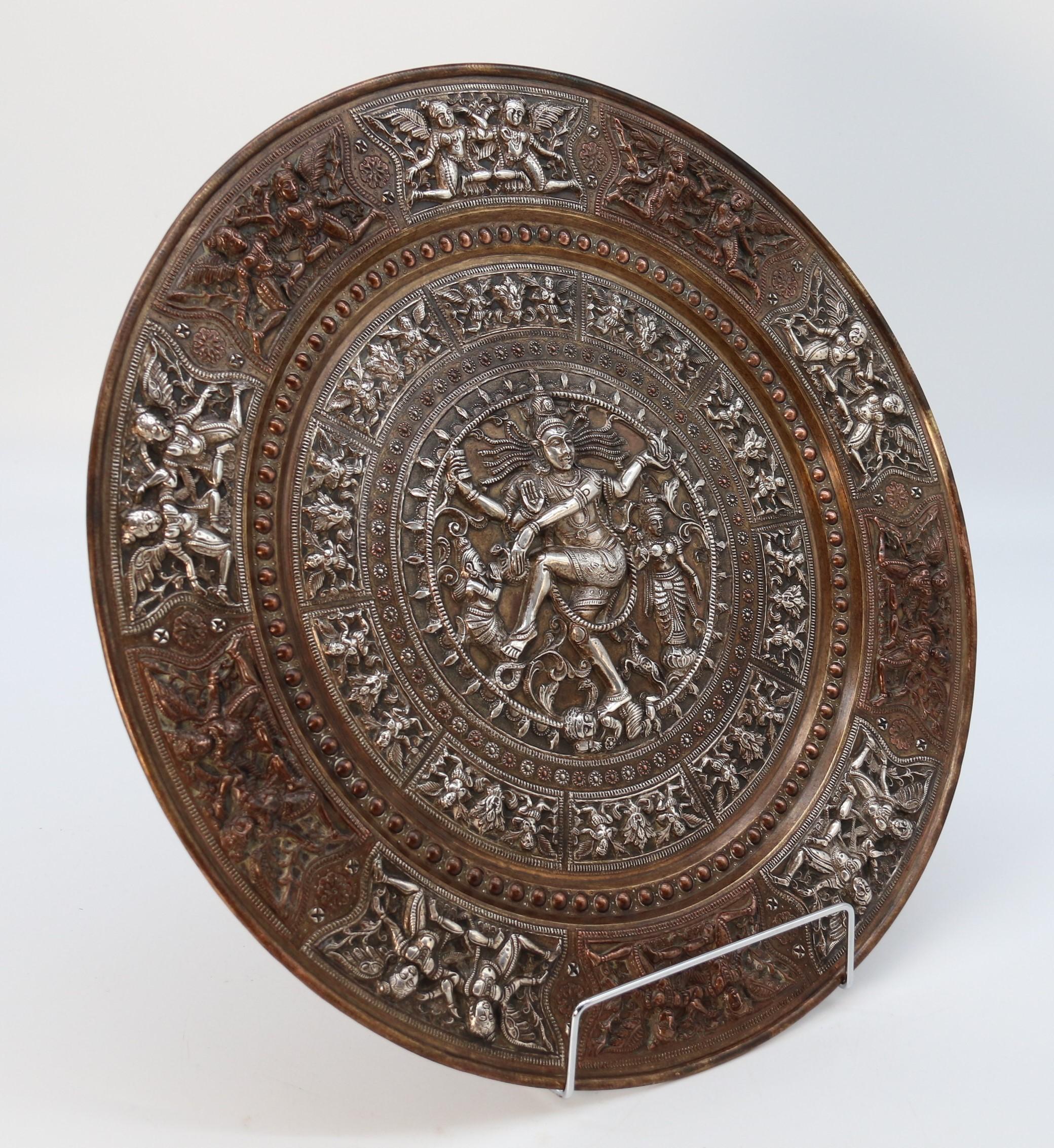 
This very fine quality late 19th century Raj period charger is made from heavy gauge brass which is extensively hand decorated with exceptionally fine applied radial panels worked in sheet silver and copper decorated with traditional scenes with
