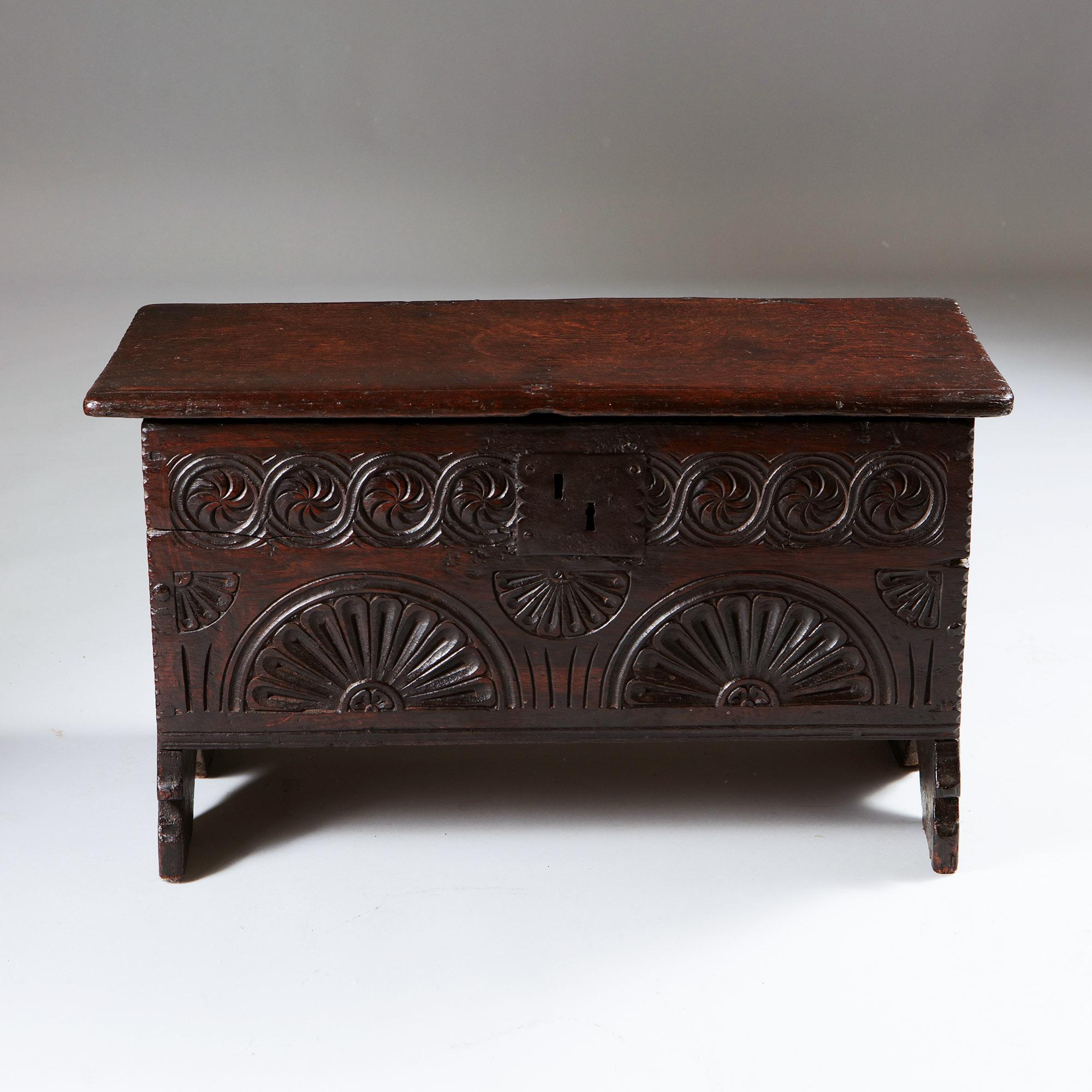 An extremely rare 17th-century early Charles II carved oak child's coffer of diminutive proportions. 


The lift-up lid opens on the originbal hinges. The frieze is crisply carved with lunar and geometric joining roundels.. Raised on the original