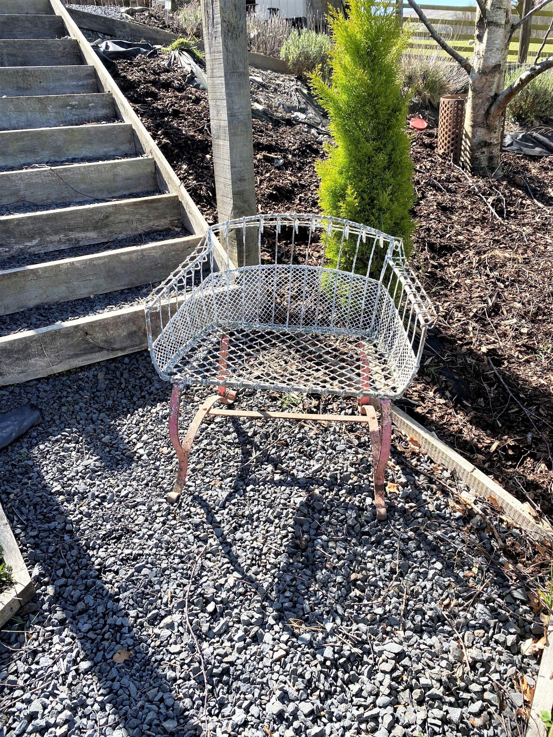 A beautiful petite Garden Seat with intricate wirework detail, sitting on rivetted wrought iron scrolled feet. These early 20th Century examples are rare to find in such lovely condition, this particular chair has an unusual shape with low back and
